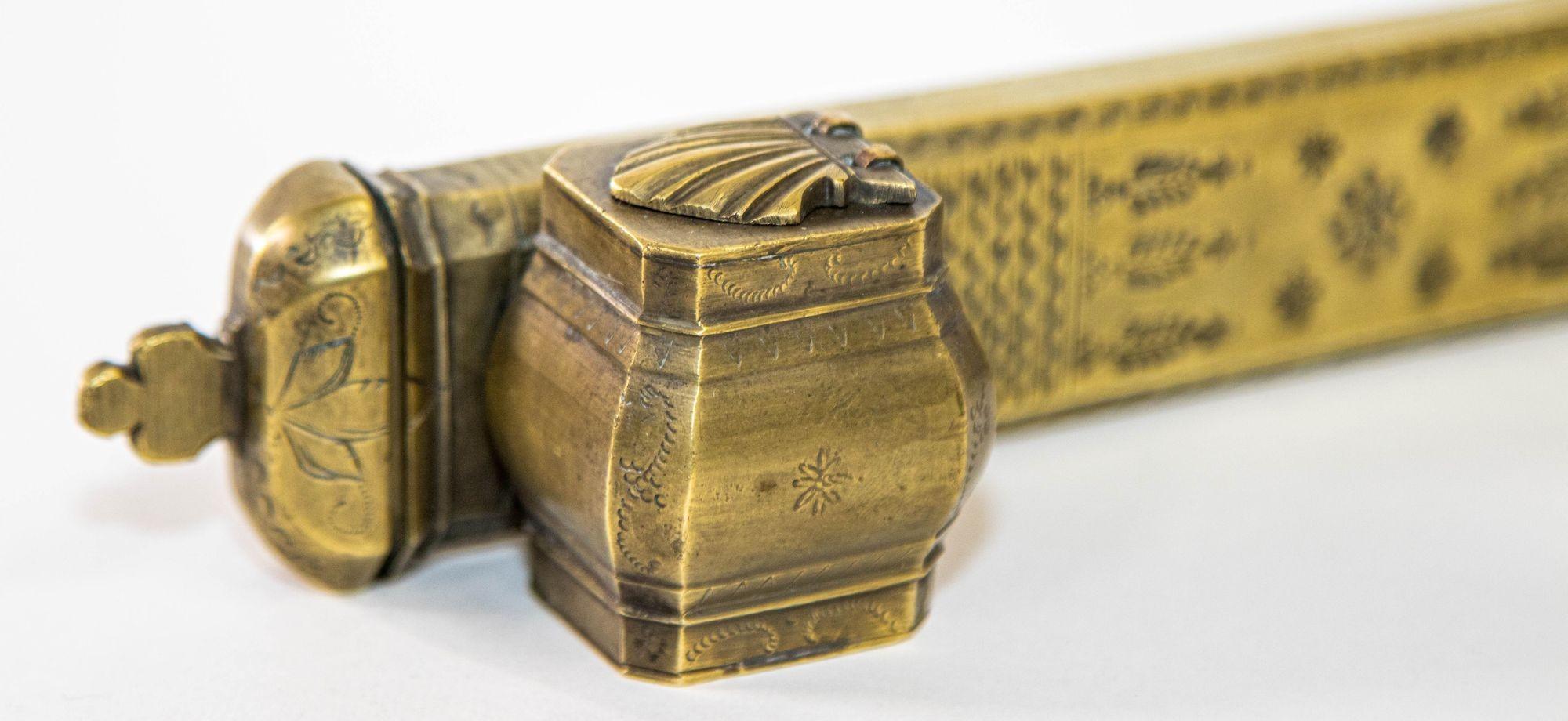 Antique Middle Eastern Brass Inkwell Qalamdan.
A 19th century brass decorated Middle Eastern Islamic Qalamdan. The Qalamdan is in solid brass, etched on all sides with engraved geometric patterns on the lapels.
It consists of an inkwell and a pen