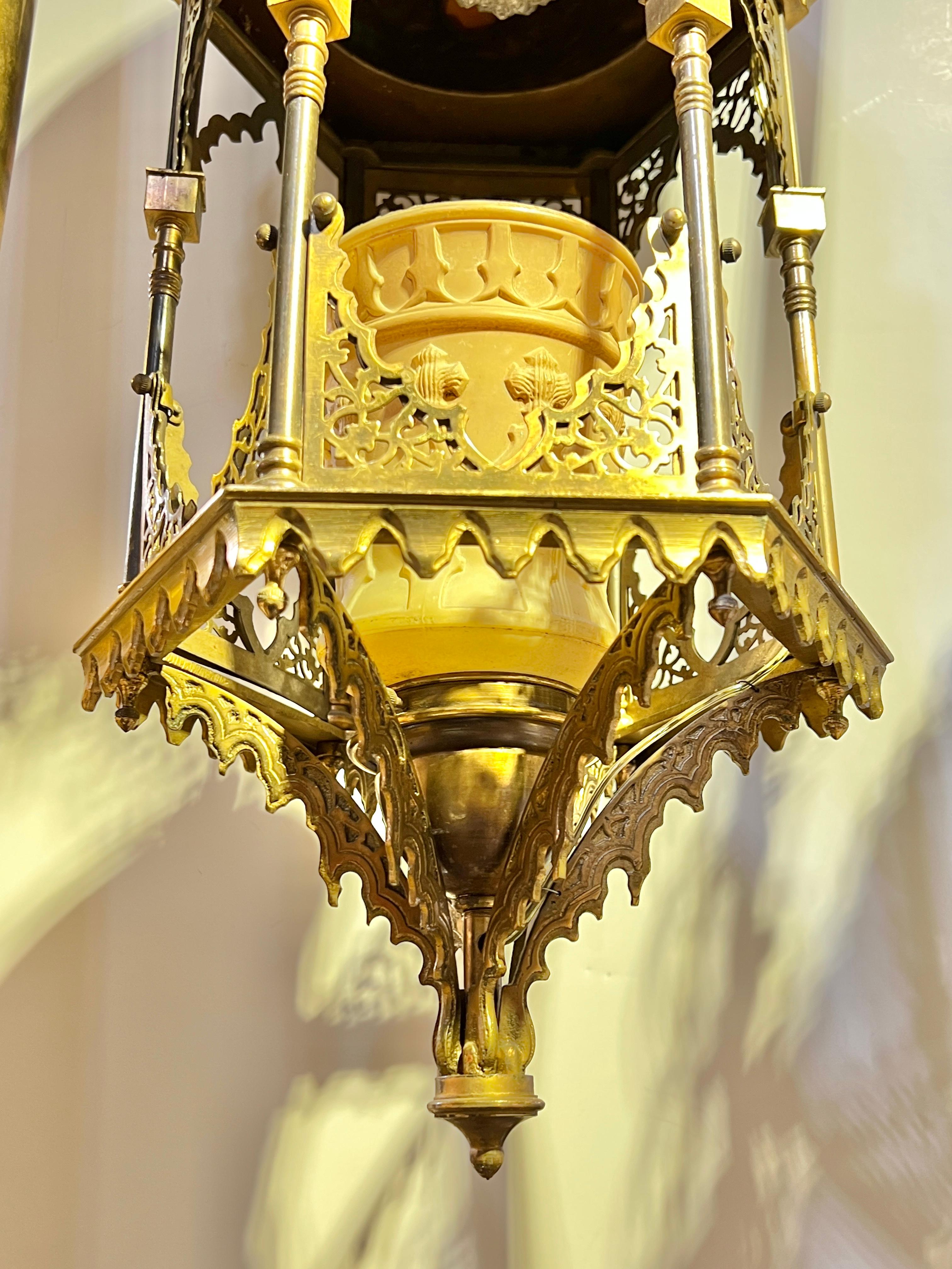 Antigua (principios del siglo XX) araña de bronce y metal en forma de farol de estilo de Oriente Medio con forma hexagonal, parte superior en forma de cúpula con joyas facetadas de cristal azul y ámbar, y pantalla original de falso cristal moldeado