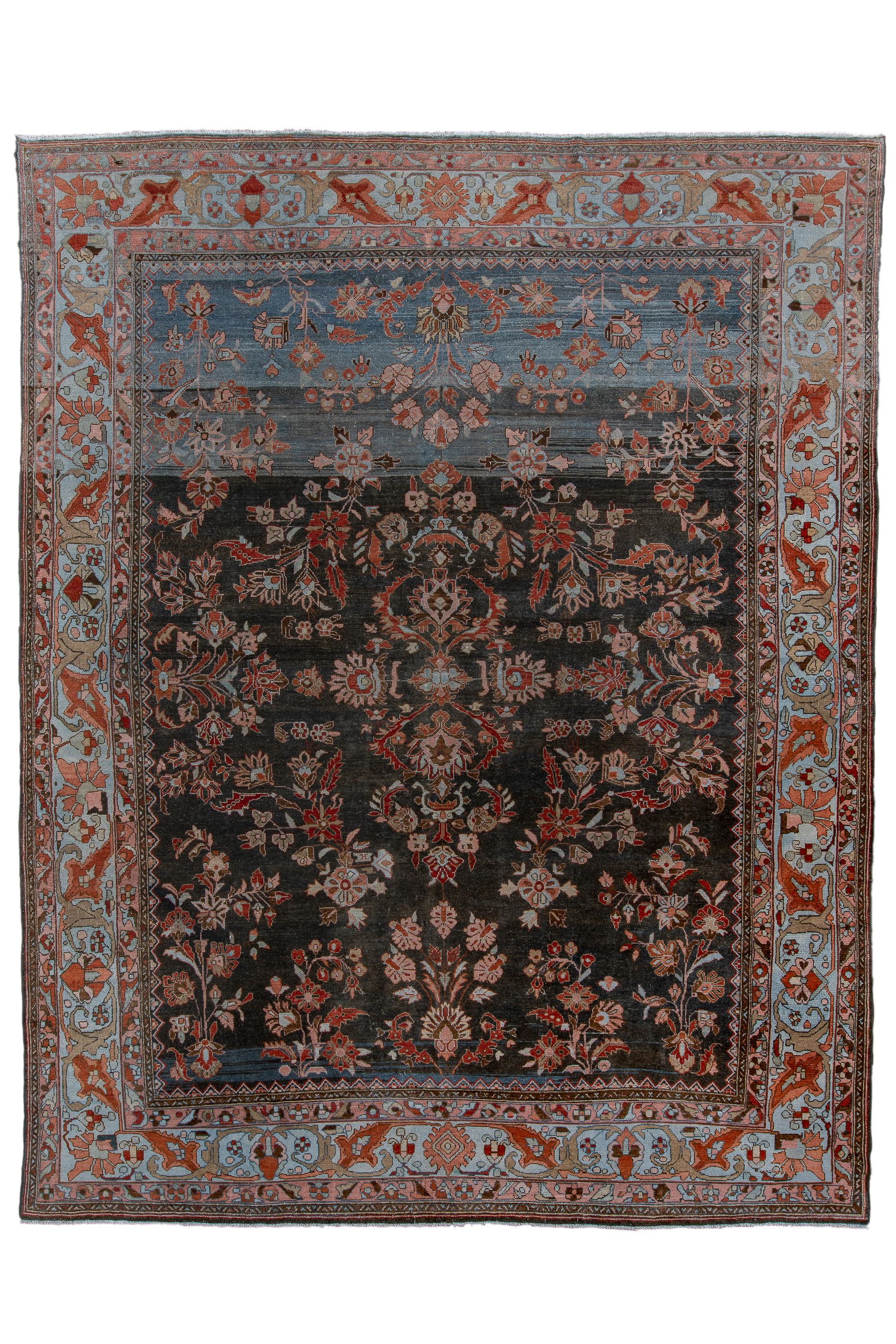 The midnite blue field abrashes to slate in the upper quarter of this village carpet from the Greater Hamadan Weaving Area.  The pattern of detached floral sprays and stems follows the popular “American Saruk” manner.  Pale blue main border with