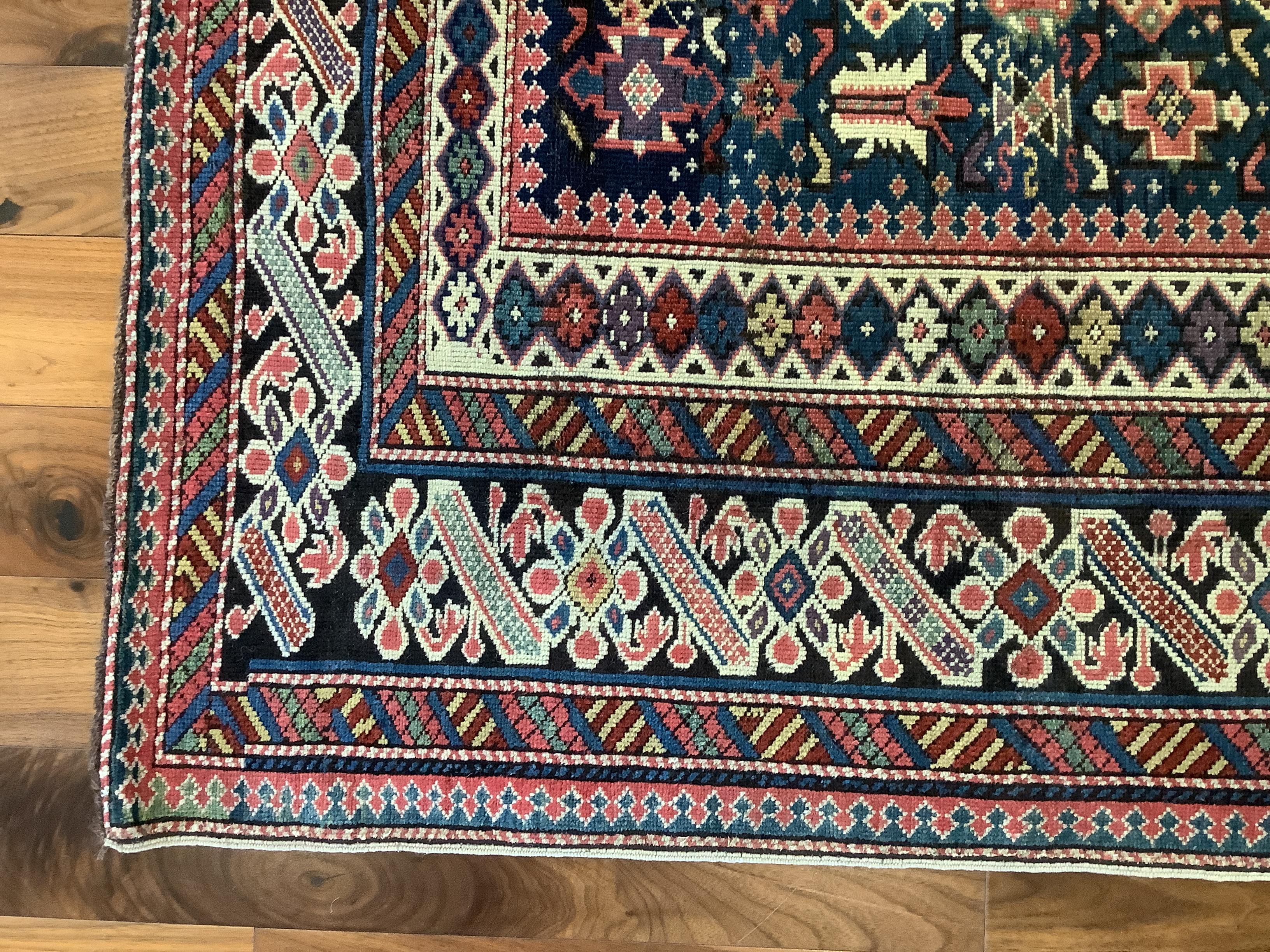 Chi Chi rugs, with their rich variety of small-format geometric motifs which hermetically cover the field and borders, are considered some of the most elaborate Caucasian weavings. The midnight green field of this piece is filled with an