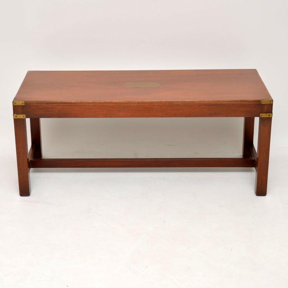Antique Campaign style mahogany coffee table in excellent condition having just been French polished. It has a brass plaque on the top and military style corner fittings. This table is very well constructed with strong legs joined by cross