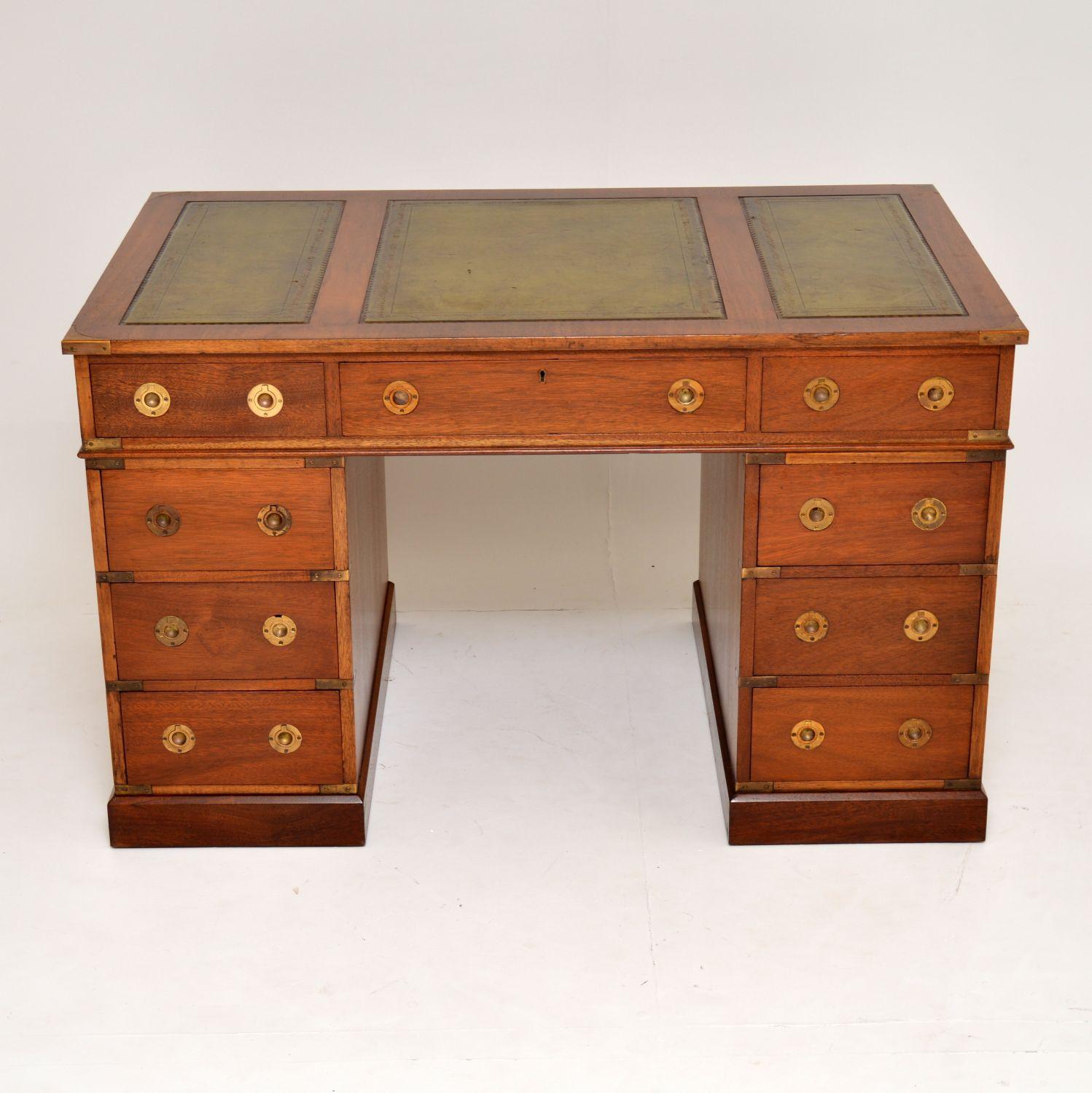 Antique Military Campaign style mahogany pedestal desk in good original condition & with lots of character.

It has a three partitioned tooled leather writing surface, brass corner fittings & inset brass naval handles on the drawers. The back is