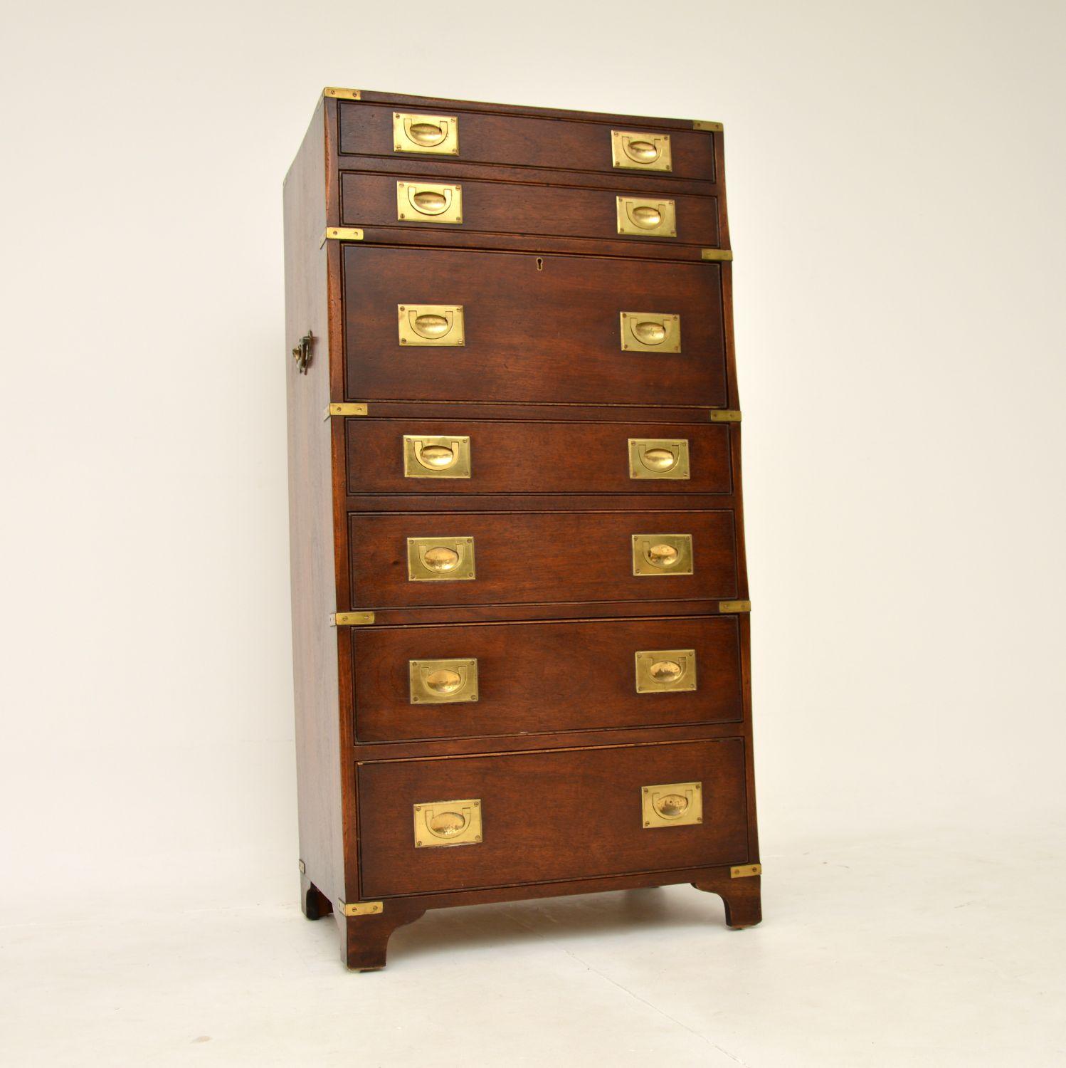 An incredible antique military campaign style chest of drawers, with a built in drop down bureau. This was made in England, it dates from around the 1930’s.

It is of exceptional quality and very compact. It’s not too wide or deep, with lots of