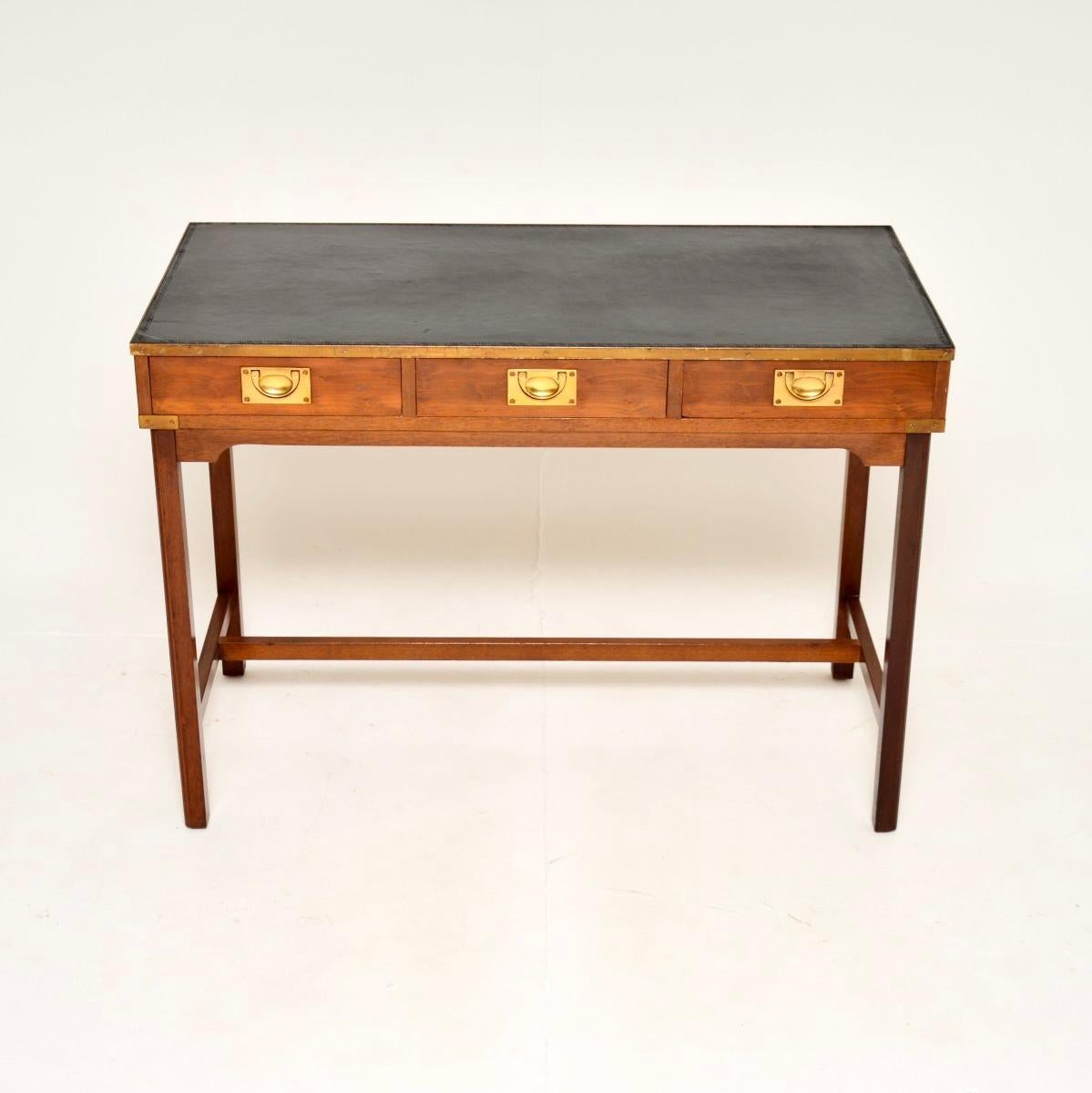 Una meravigliosa scrivania antica in stile campagna militare in legno di tasso, risalente agli anni '50 circa.

È di ottima qualità, con graziose finiture in ottone e un bellissimo piano in pelle nera. La base è allungata e anche il retro è ben
