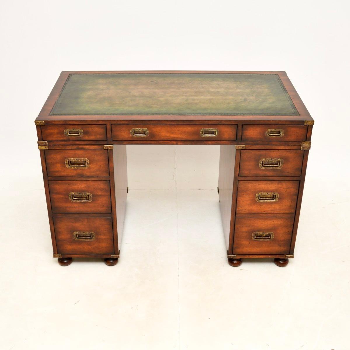 A smart and extremely well made antique military campaign style pedestal desk. This was made in England, it dates from around the 1950’s.

It is of superb quality, it is very heavy and sturdy. There is an inset green leather writing surface, the