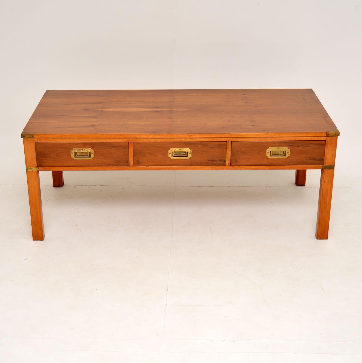 Antique Military Campaign style large coffee table in yew wood with brass corner fittings and sunken brass military drawer handles. It has a lovely mellow color and a nice grain to the wood all-over. There are three drawers on one side and the other