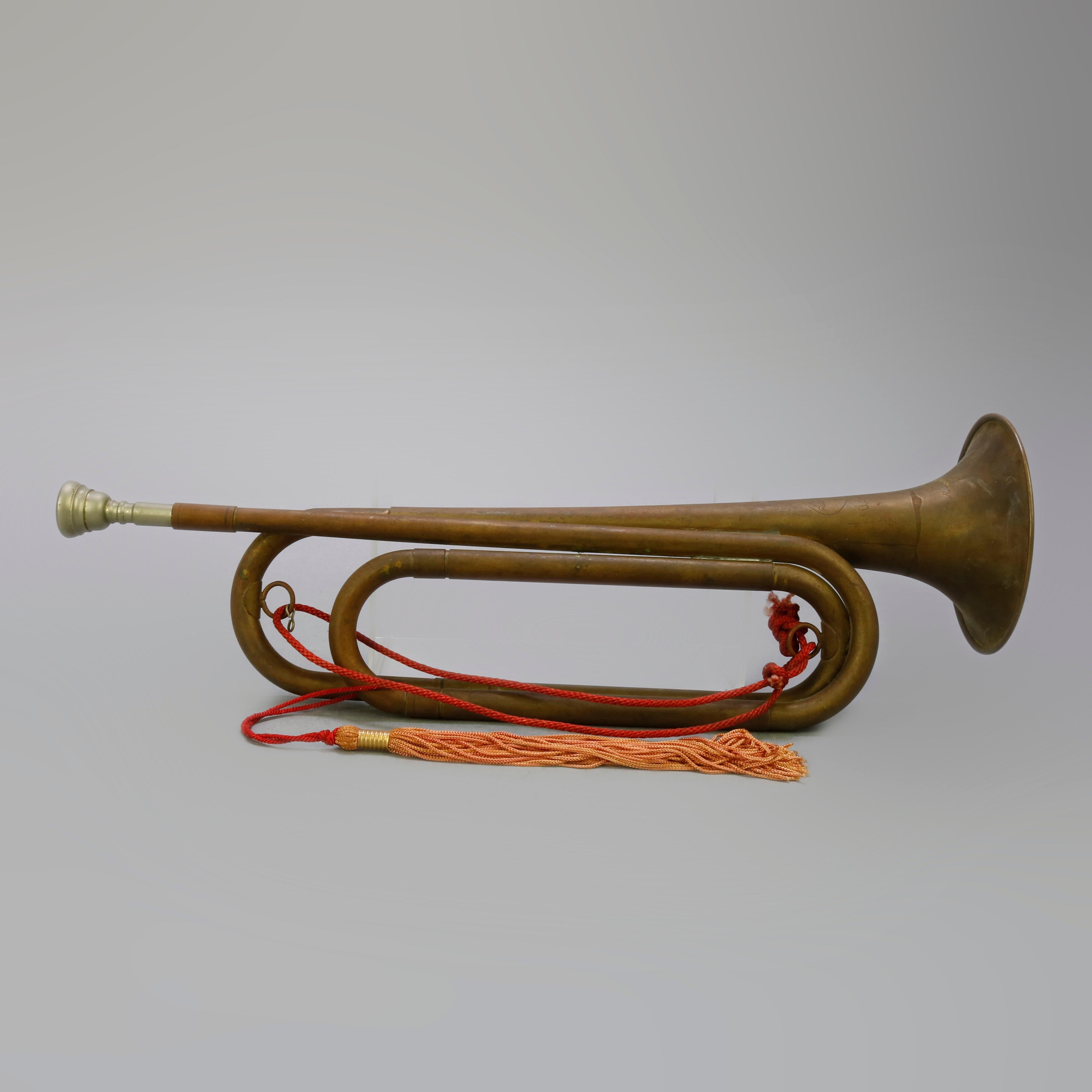 An antique Military issued brass infantry bugle with cord and tassel, 20th century

Measures- 6