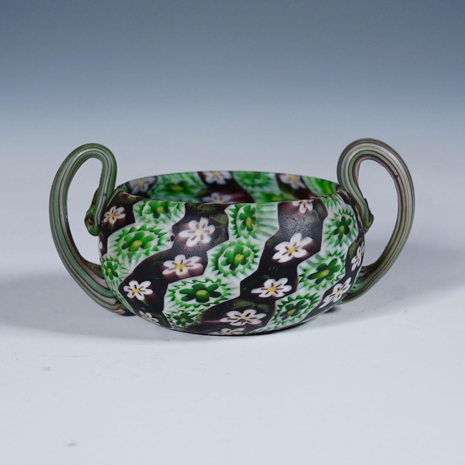 Antike Millefiori-Schale mit Henkeln, Fratelli Toso Murano ca. 1900s

Kleine Millefiori-Murringlasschale mit zwei Henkeln, hergestellt von Vetreria Fratelli Toso, Murano um 1900. Hergestellt aus polychromen Murrinen in Violett, Grün und Weiß, die