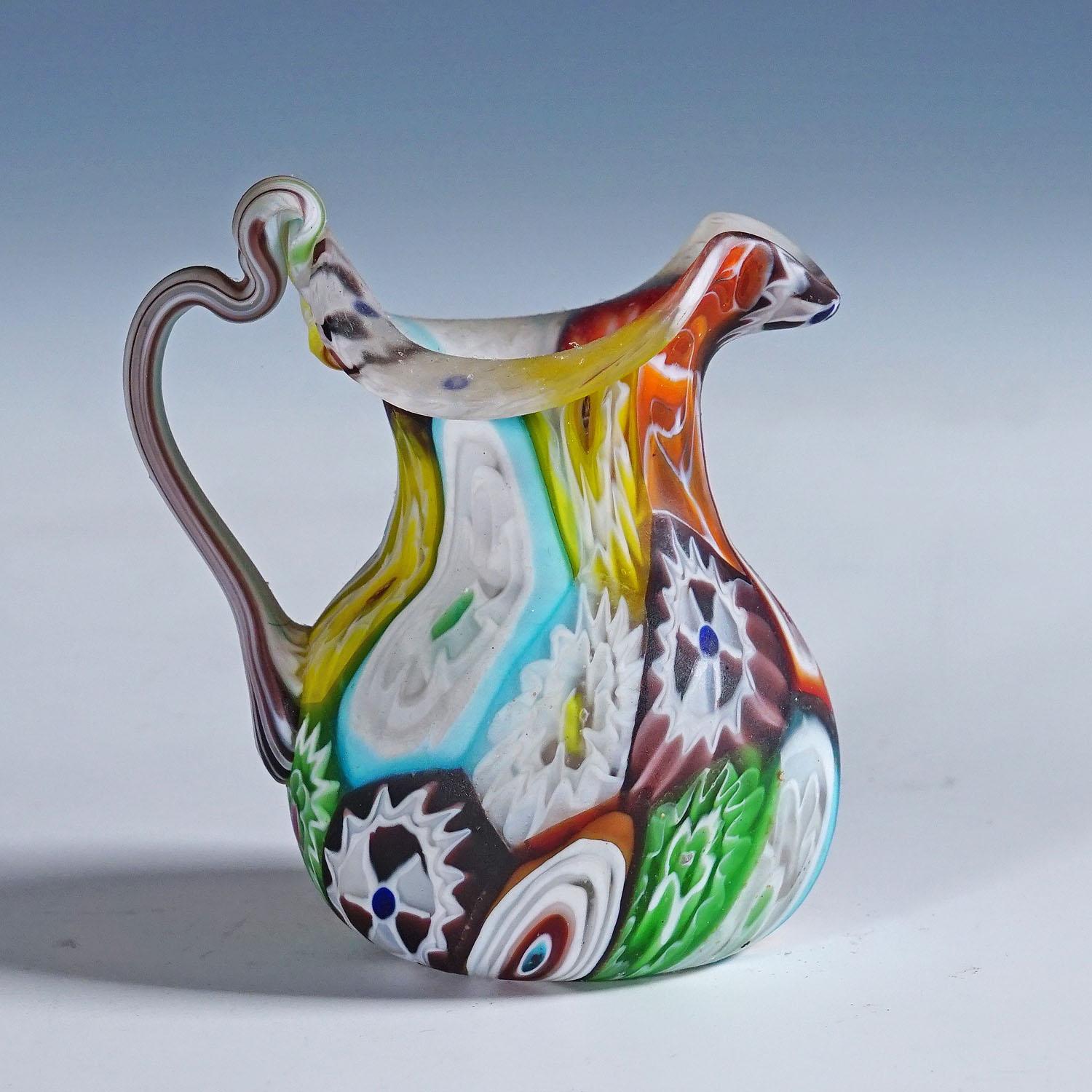 Una colorata brocca in vetro millefiori di Murano prodotta dalla Vetreria Fratelli Toso, intorno al 1920. Realizzato con murrine policrome multicolori che sono state fuse insieme. Superficie con finitura opaca acidata. La brocca è un autentico