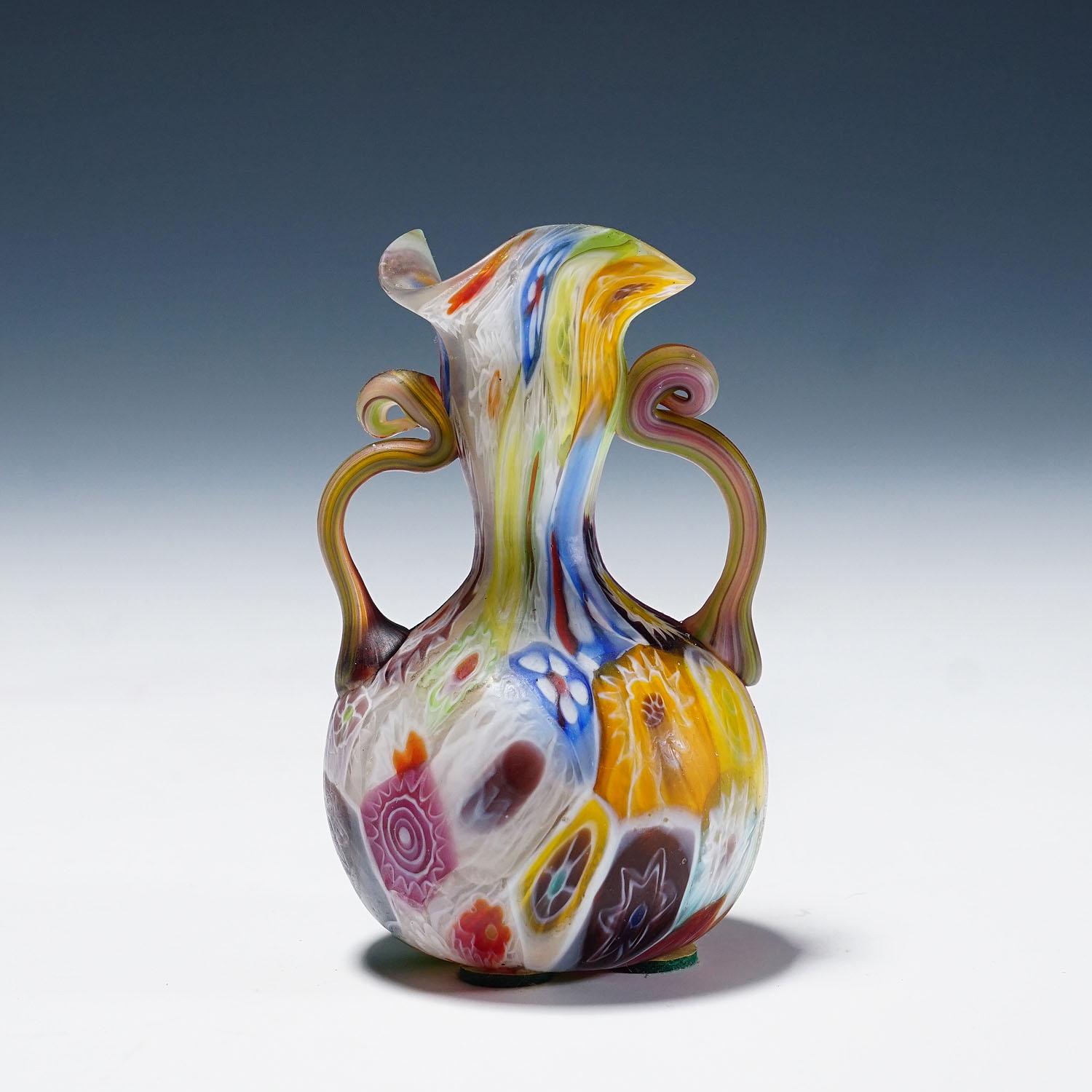 Jarrón Millefiori antiguo con asas, Fratelli Toso Murano ca. 1920s

Pequeño jarrón de cristal millefiori murrino fabricado por Vetreria Fratelli Toso, Murano, hacia 1920. Hecha de murrinas polícromas multicolores que se fundieron entre sí.