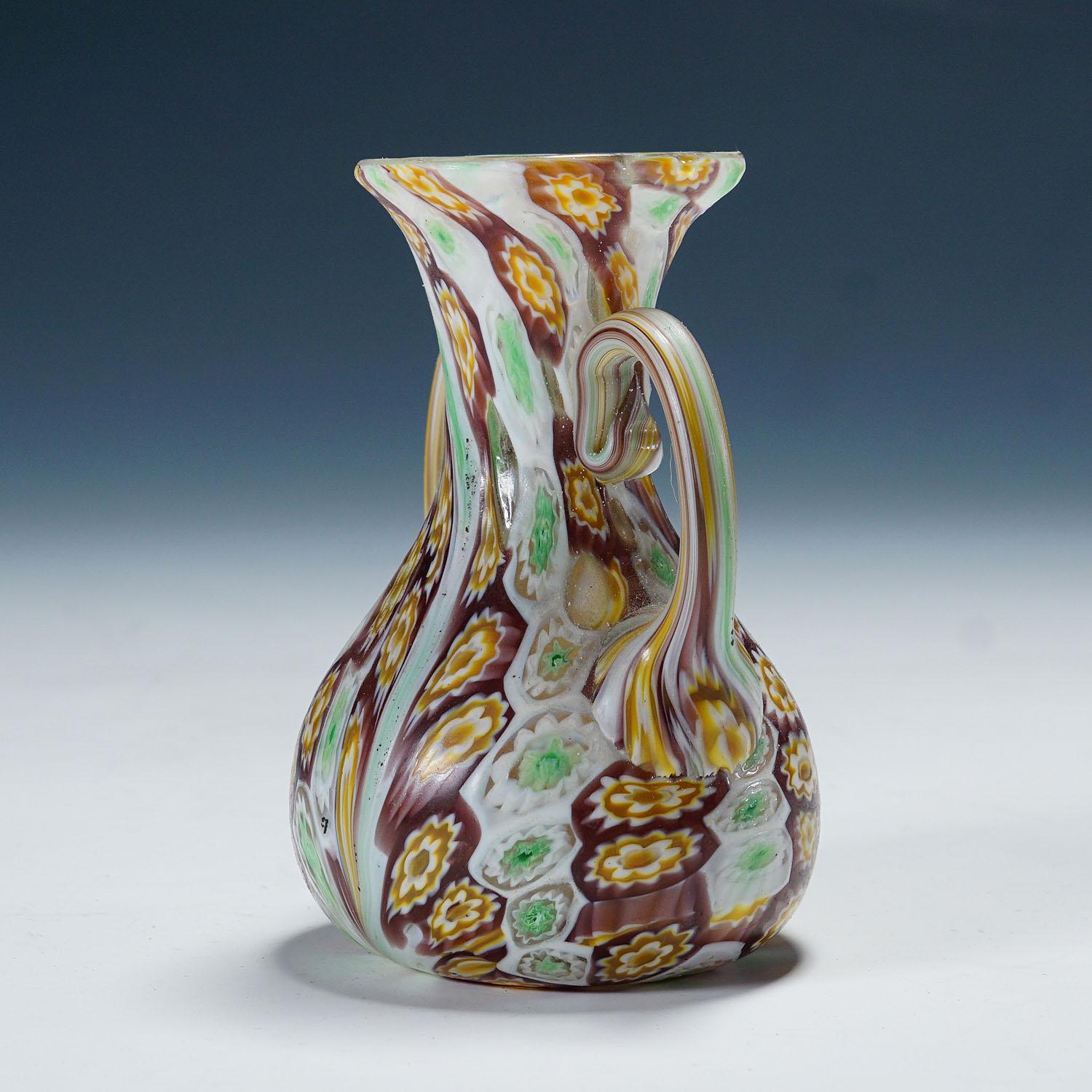 Antique Millefiori Vase with Handles, Fratelli Toso Murano ca. 1920s

A great millefiori murrine glass vase manufactured by Vetreria Fratelli Toso, Murano around 1920. Made of polychrome murrines in purple, green, orange and white which were melted
