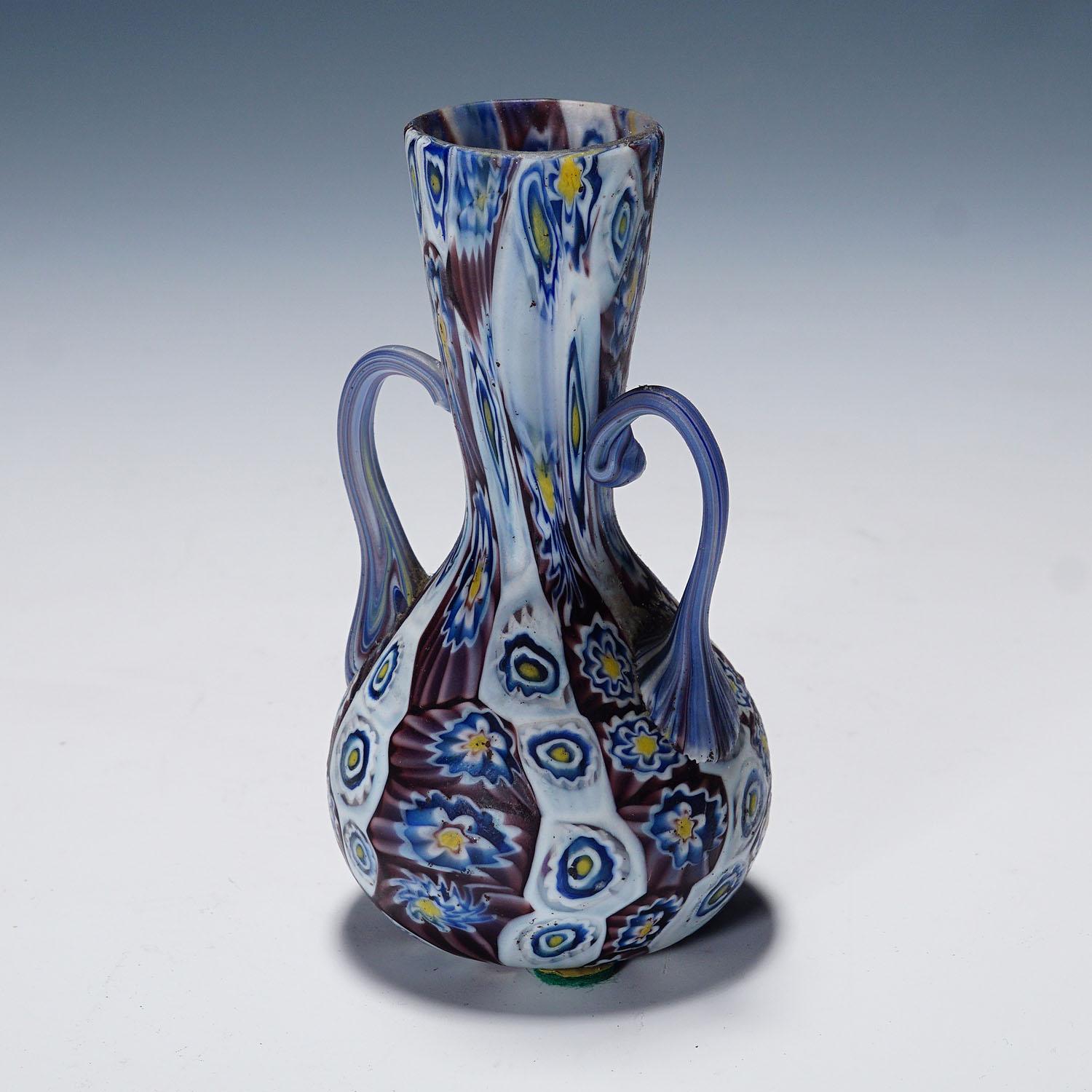 Antique Millefiori Vase with Handles, Fratelli Toso Murano

A great millefiori murrine glass vase manufactured by Vetreria Fratelli Toso, Murano in the early 20th century. Made of polychrome murrines in purple, blue, yellow and white which were
