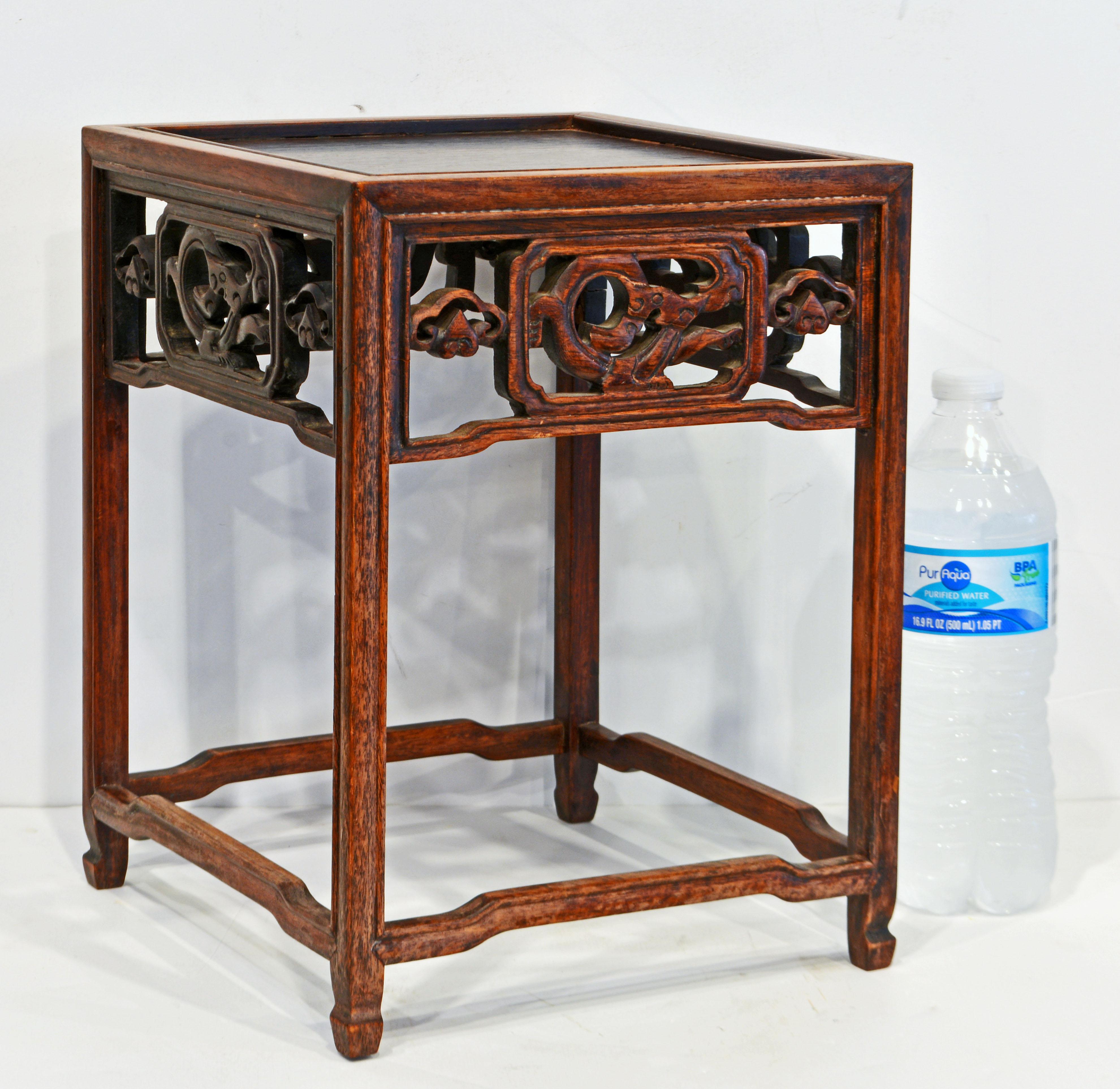 This small Chinese Ming style table stand, likely dating to the late 19th century is made of Huanghuali wood using the best traditional craftsmanship. Under the top there are carved openwork friezes on carved shaped legs and stretchers. For its size