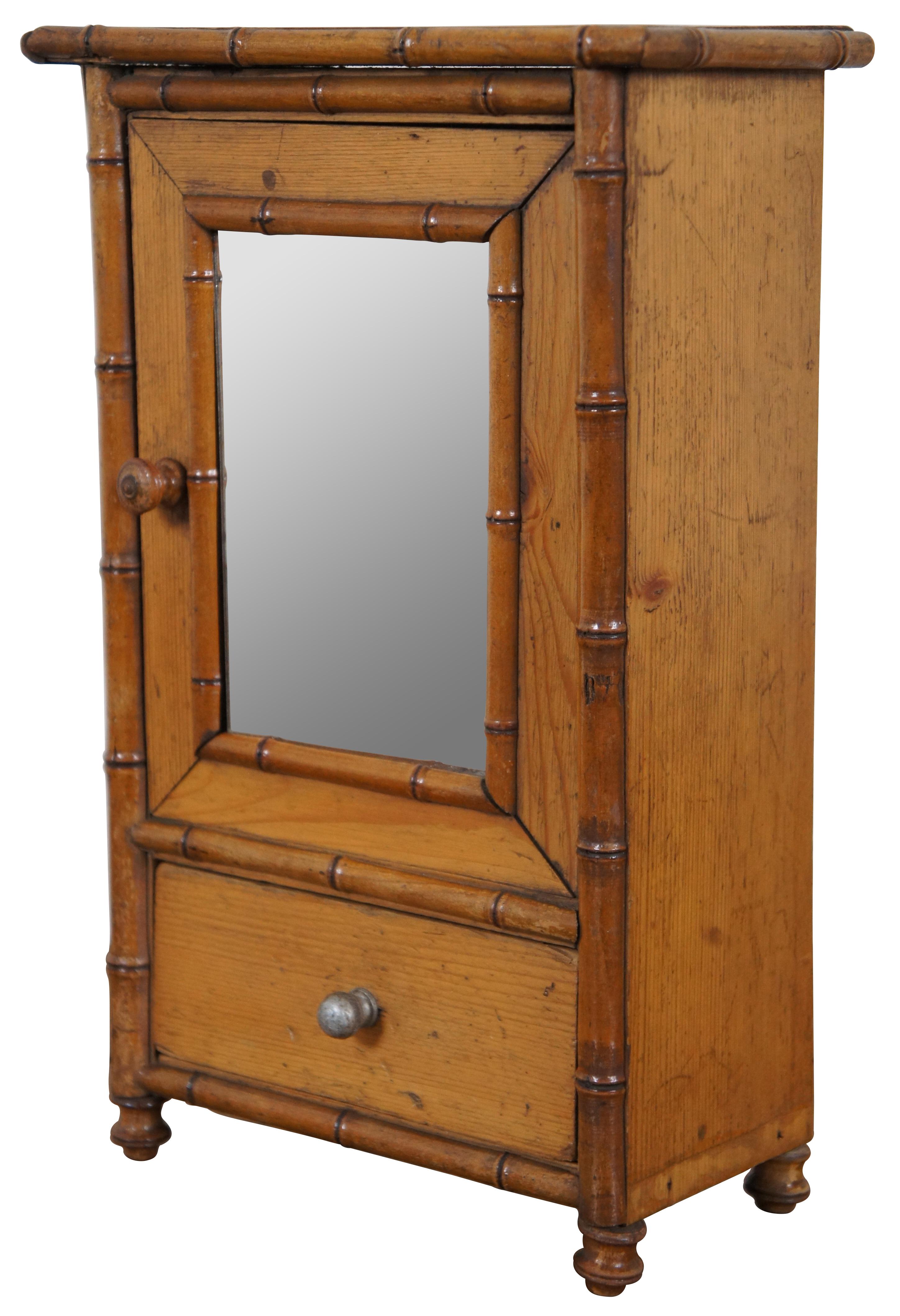 Early 20th century doll furniture miniature wardrobe featuring a bamboo frame, mirrored door and lower drawer for accessories.