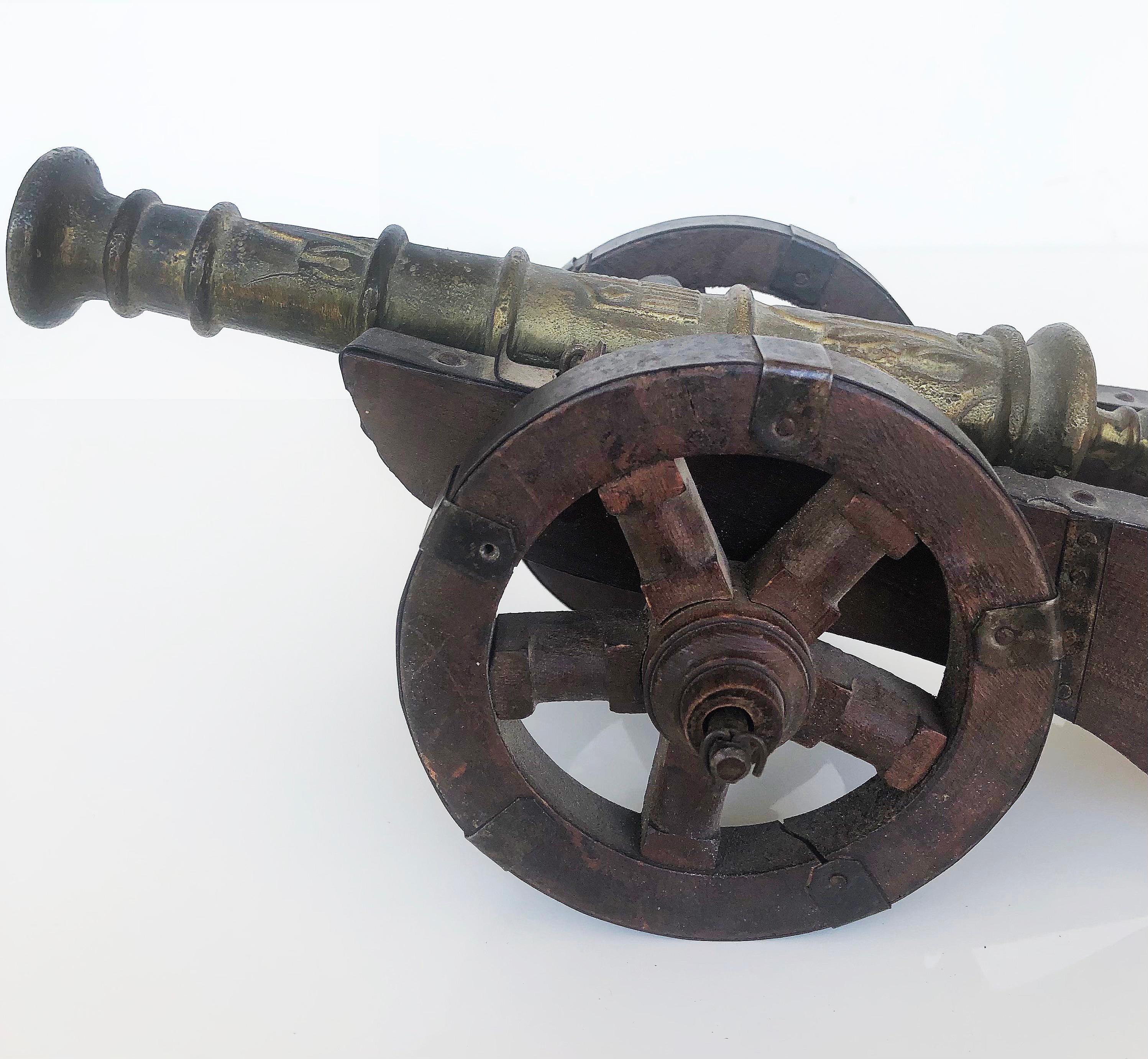 Antique miniature bronze cannon on carriage with wood & metal

Offered is an antique miniature bronze cannon on carriage with wood wheels and metal trim. This will look good on a desk or displayed on shelves.