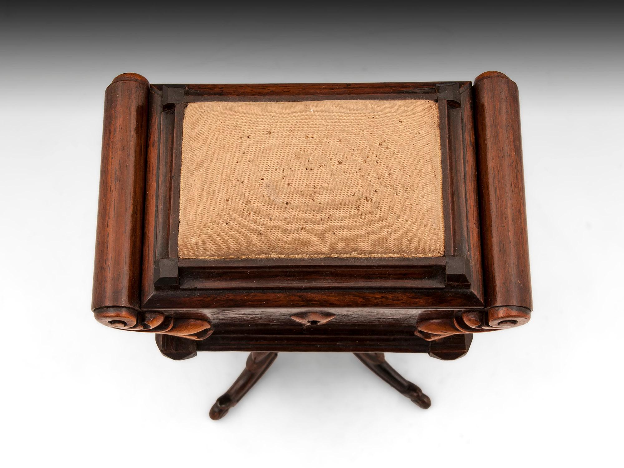 Charming miniature mahogany sewing table box with a beautifully carved exterior and topped with a pincushion.

The interior is lined with patterned paper and the underside of the lid is decorated with finely painted flowers.

This sewing box