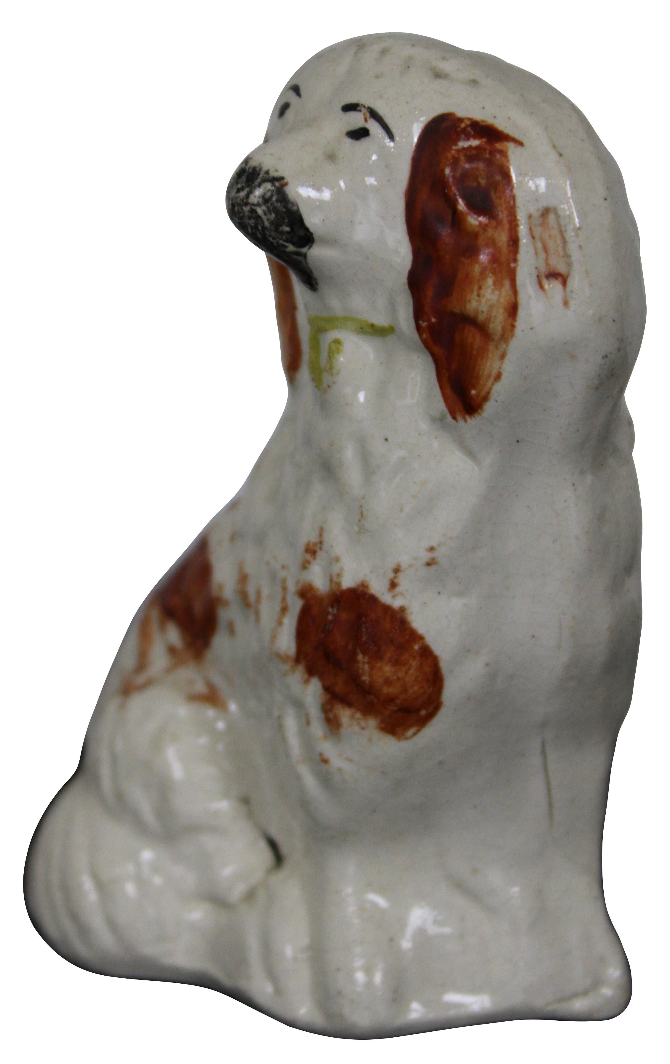 Antique miniature Staffordshire porcelain figurine in the shape of a red and white King Charles spaniel with gold collar.