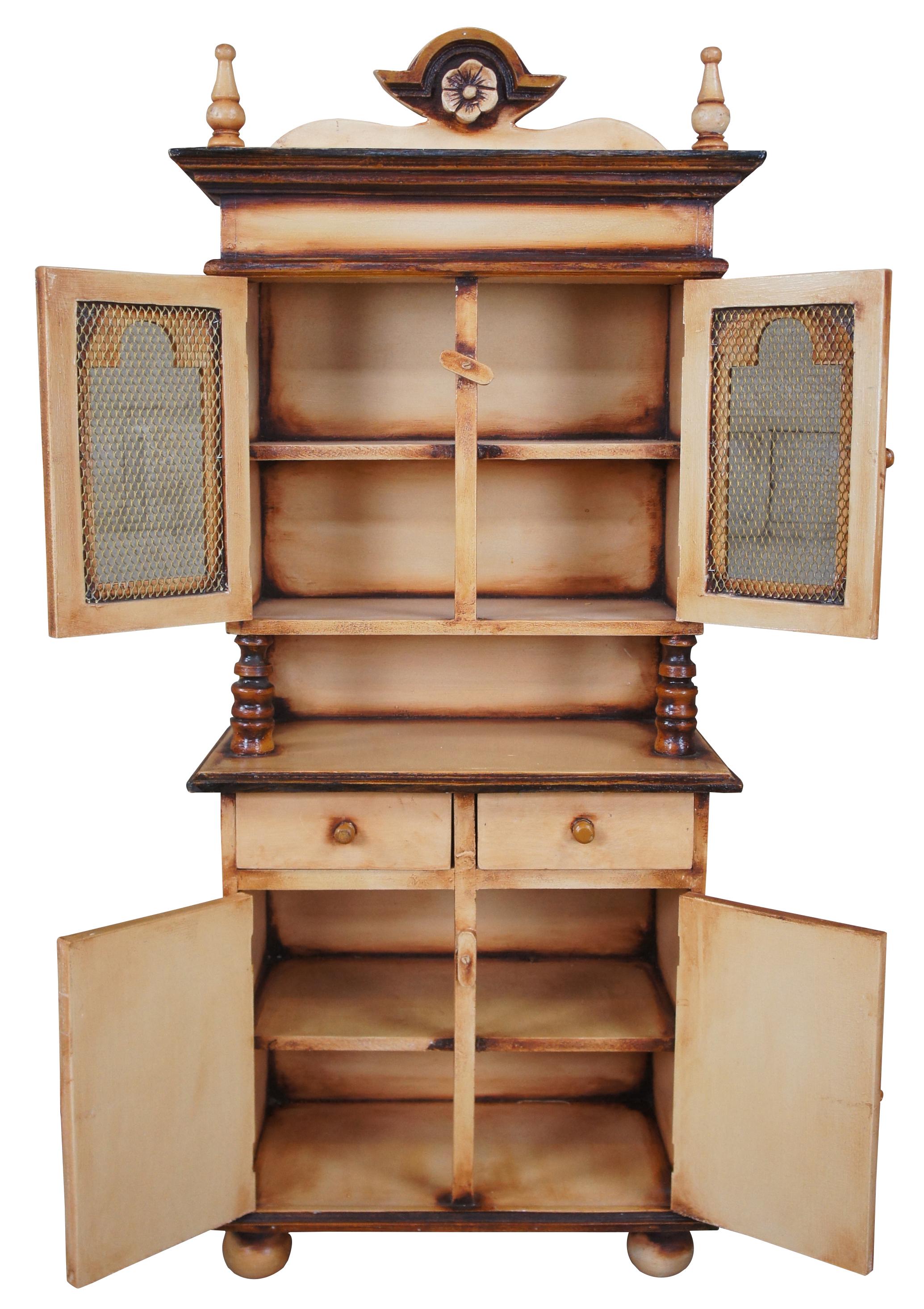 Antique miniature Folk Art stepback cupboard with wire mesh doors, turned supports and bun feet. Measure: 42