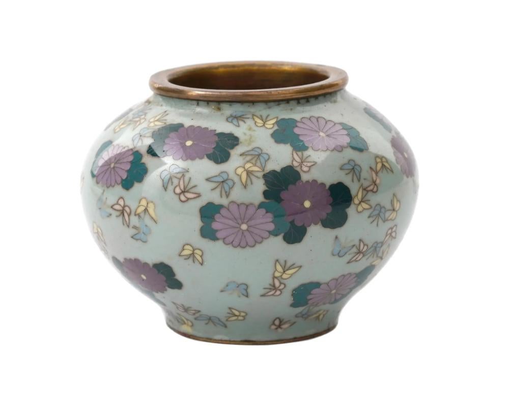 A miniature Japanese Meiji period vase, 1868 to 1912. The globular vase slightly tapering to the bottom decorated in polychrome enamels and copper wires depicting dark and light purple chrysanthemums with aquamarine leaves, and pink, yellow and blue