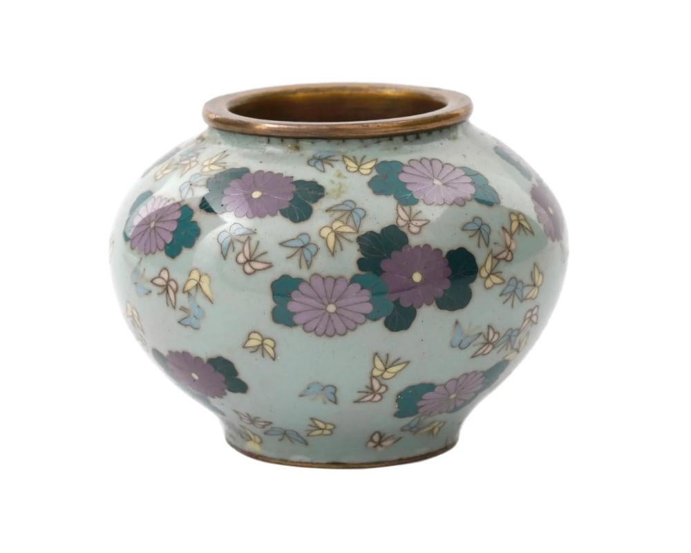 Vaso giapponese in miniatura del periodo Meiji, dal 1868 al 1912. Il vaso globulare leggermente affusolato verso il fondo è decorato con smalti policromi e fili di rame che raffigurano crisantemi viola scuro e chiaro con foglie acquamarina e