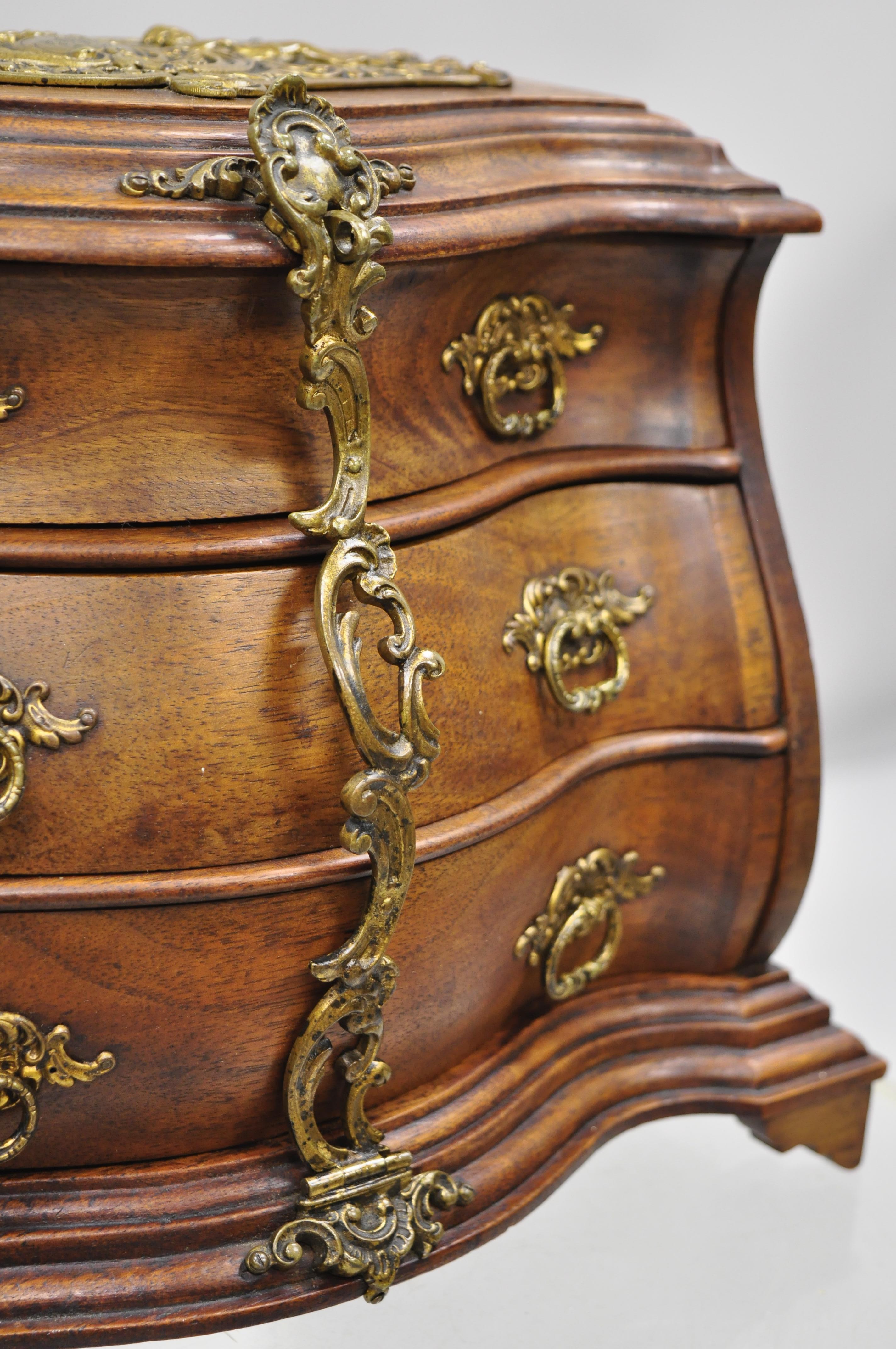 Antique miniature mahogany & brass continental bombe jewelry box chest. Item features cast brass ormolu, sleek bombe form, plaque with cherubs to top, solid wood construction, no key or lock, very nice antique item, quality craftsmanship, circa