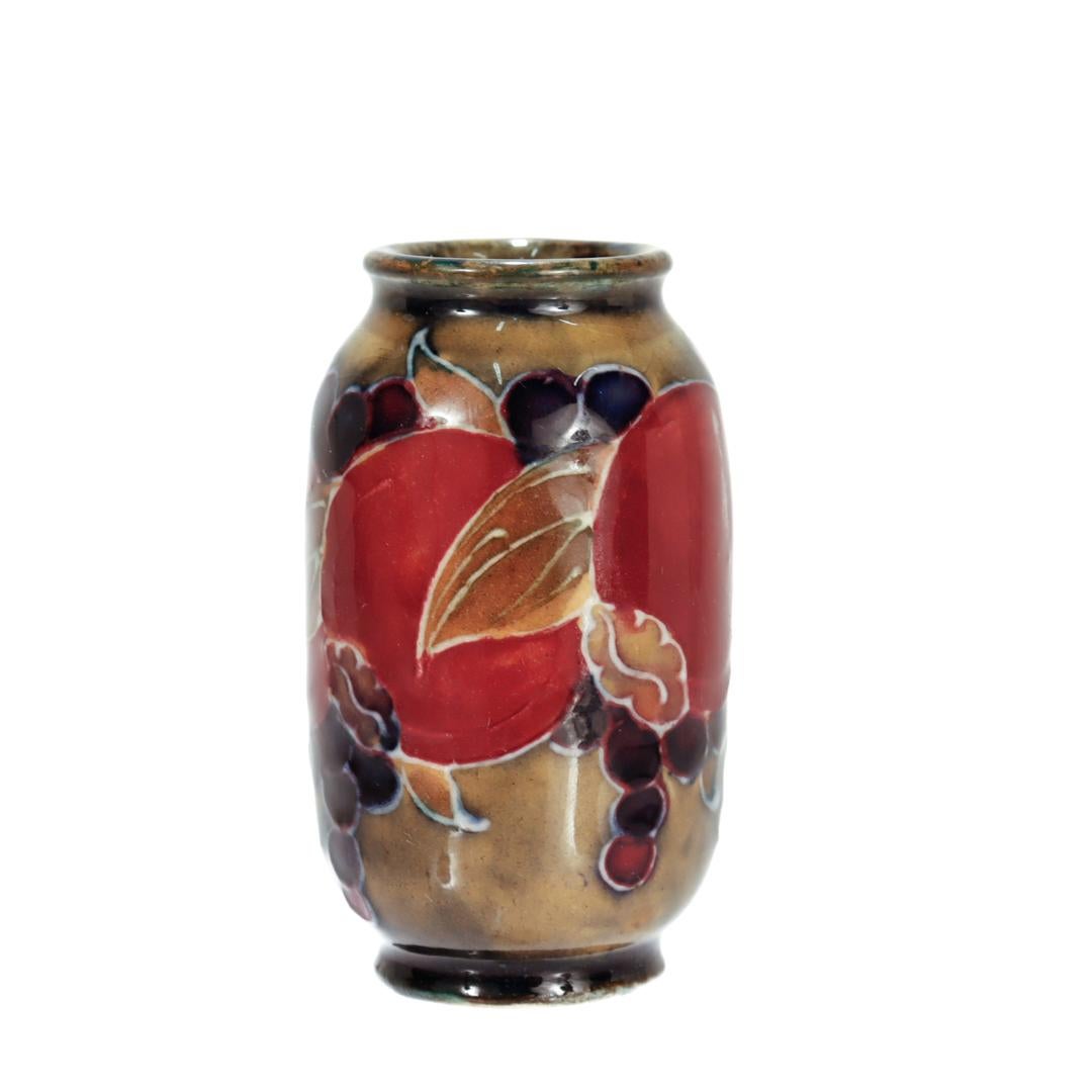Eine feine antike Miniatur Moorcroft Keramik Vase.

Mit dem Granatapfel-Muster.

Mit gelb gesprenkeltem Grund und durchgehend polychromem Dekor.

Wahrscheinlich hergestellt und vertrieben von Liberty & Co. ca. 1910-1911.

Auf dem Sockel mit