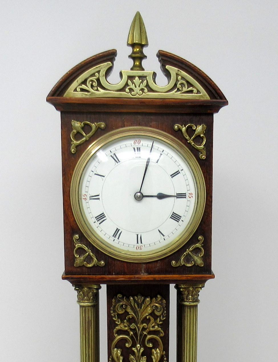 An Exceptionally fine English well figured oak miniature longcase mantle clock of outstanding quality, with lavish polished brass decorative mounts, last quarter of the 19th century. 

The central main support with lavish cast polish brass mounts