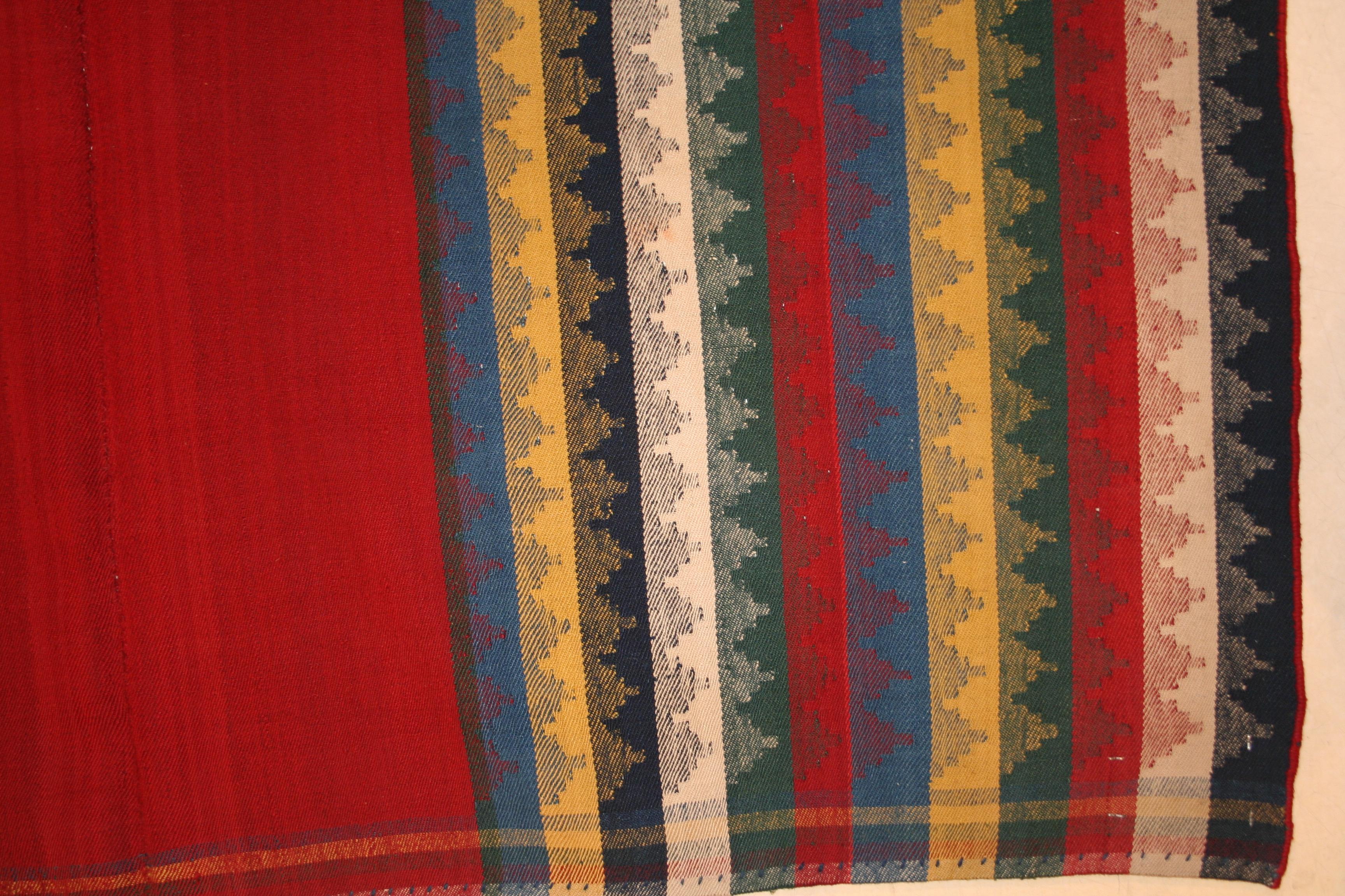 A dazzling flat-weave distinguished by a rich red open field background flanked by polychrome vertical stripes. Kilims of this kind, although belonging to the material culture of near eastern tribes, are surprisingly modern in conception and