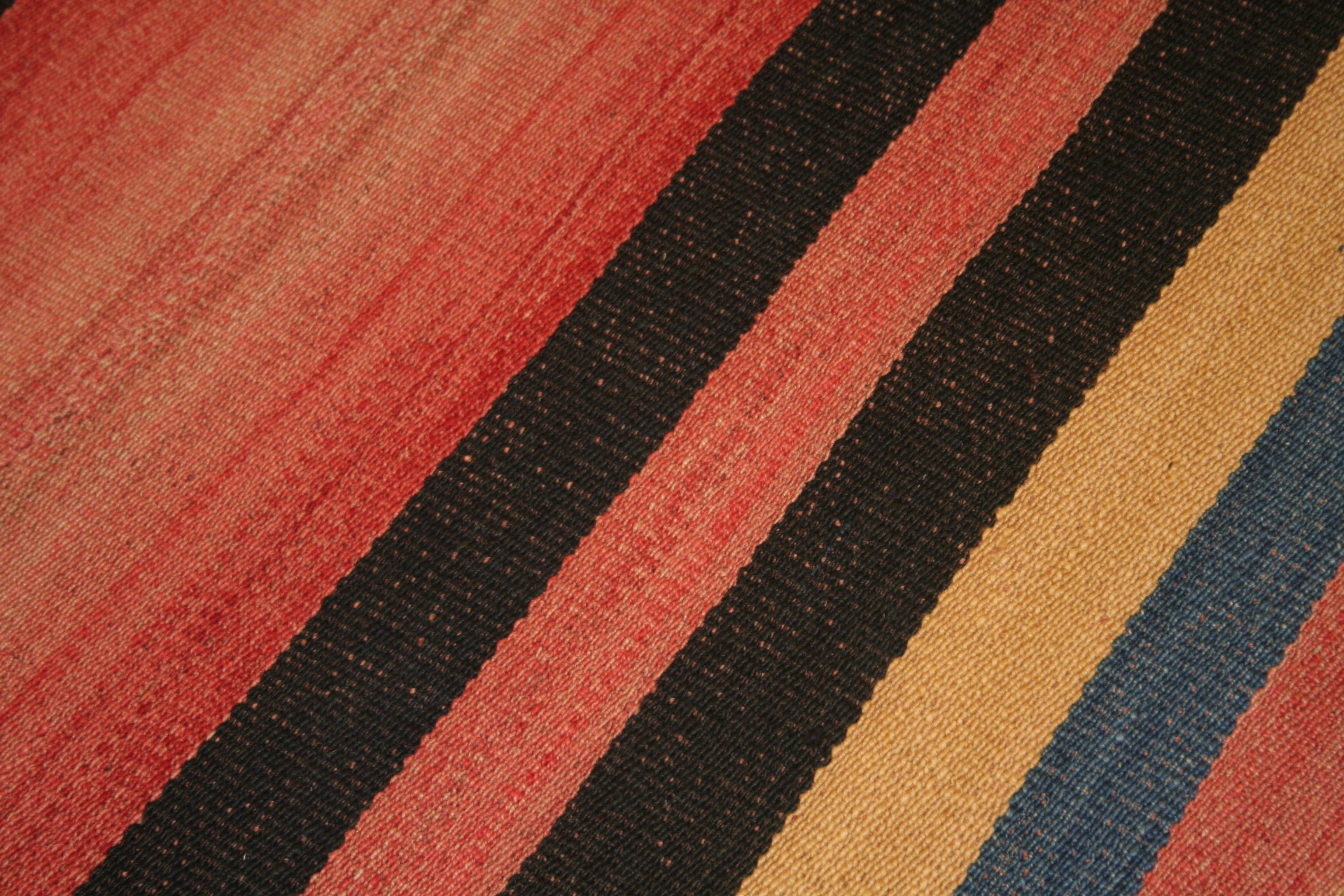 A very graphic tribal Kilim composed of two joined panels each containing an array of polychrome vertical stripes of various widths. The result is a wool flat-weave with a mirror image pattern having a central stripe that is considerably wider than