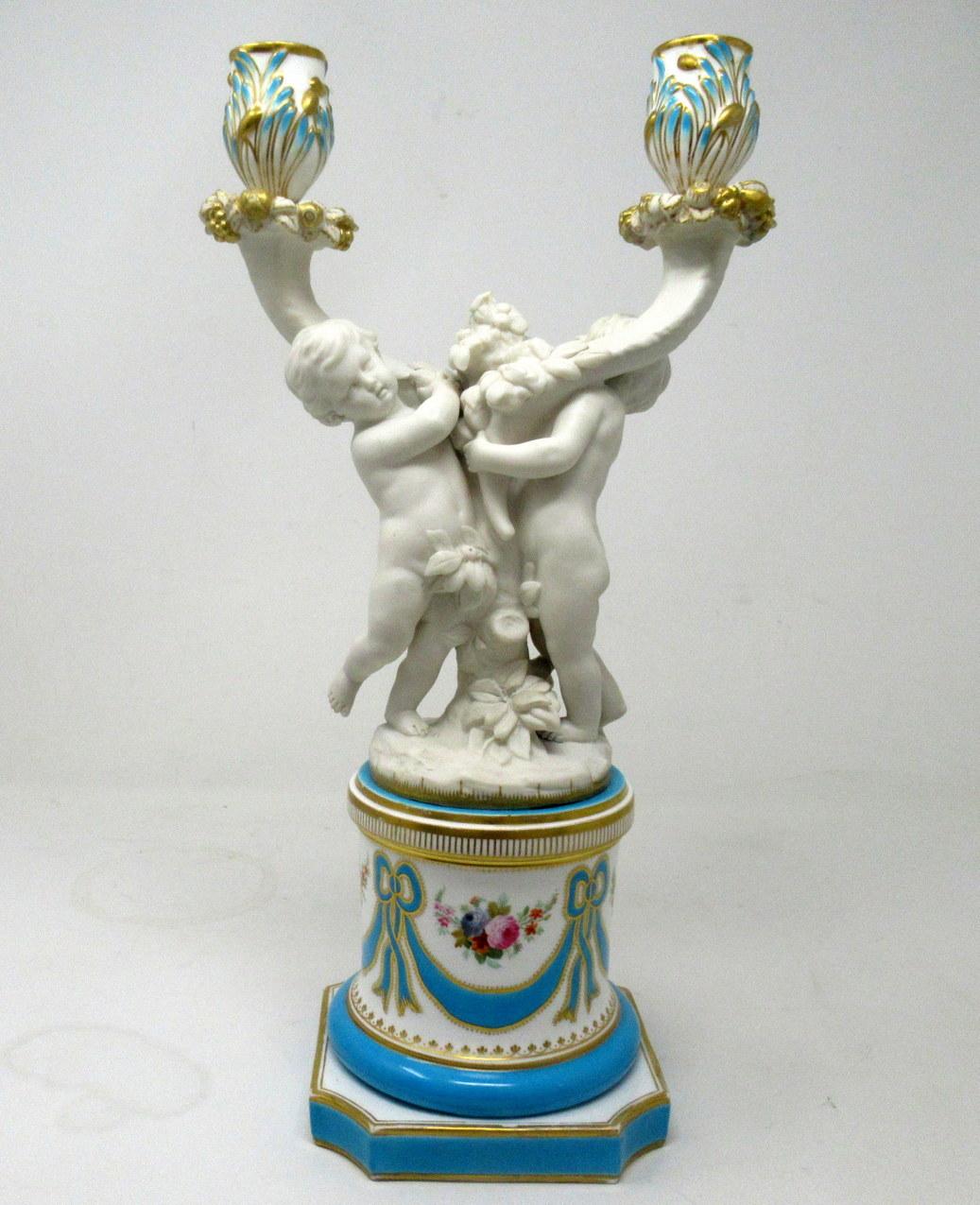 Stunning Example of an English Minton Porcelain two branch candelabra, modelled as a group of Cherubs standing on naturalistic base above an elaborate reeded socle with lavish decoration depicting gilt framed medallions with hand paintings of still