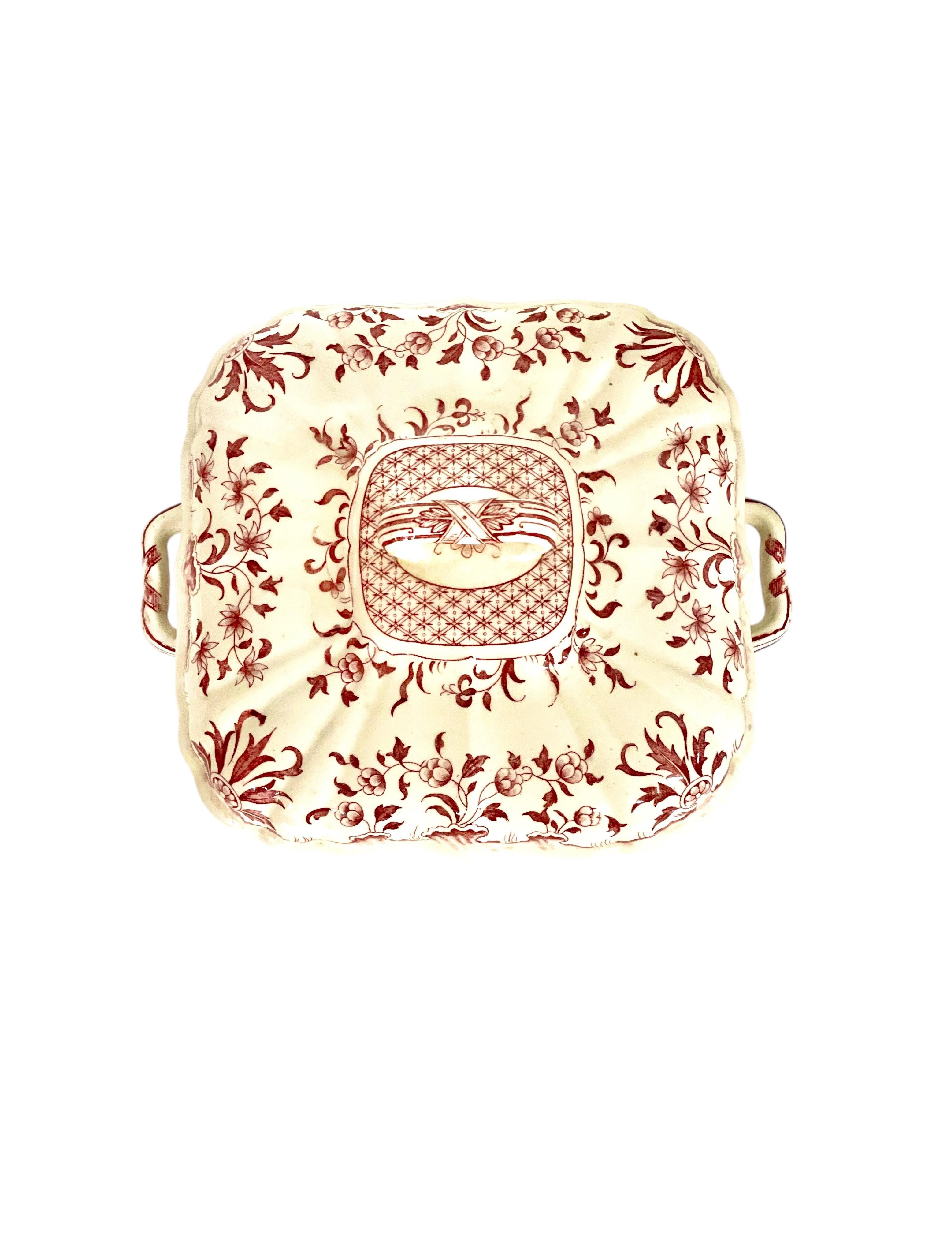 Esta exquisita fuente para verduras con tapa, también conocida como sopera o fuente de servir, fue fabricada por la renombrada alfarería Minton's de Stoke-on-Trent, Inglaterra, a finales del siglo XIX. La pieza forma parte del patrón 