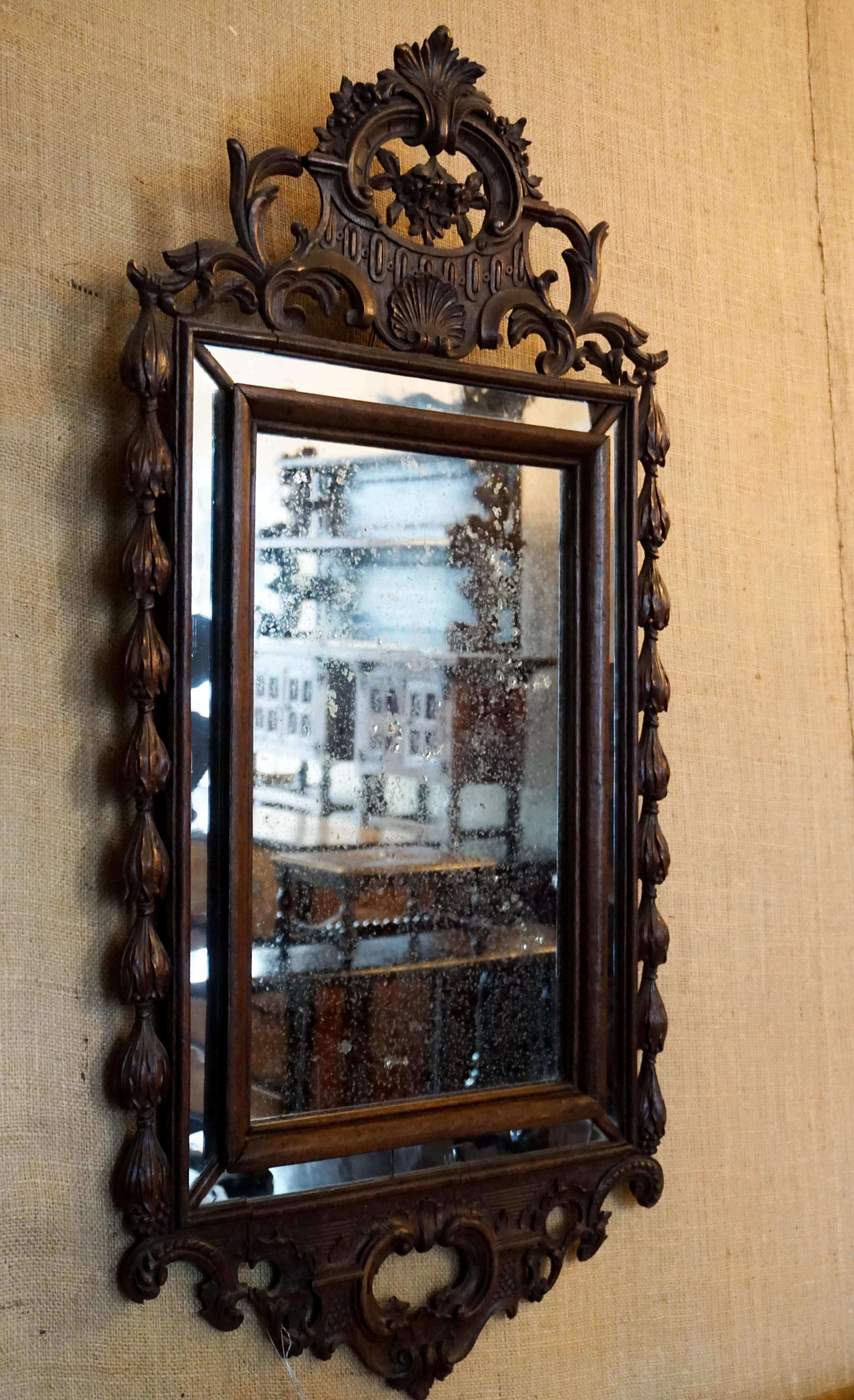 Here we have a mid-sized, wooden, French mirror with intricate carvings featuring a centre shell with lovely floral designs and beaded designs on the sides. 

Origin: France circa 1750

Measurements:
1