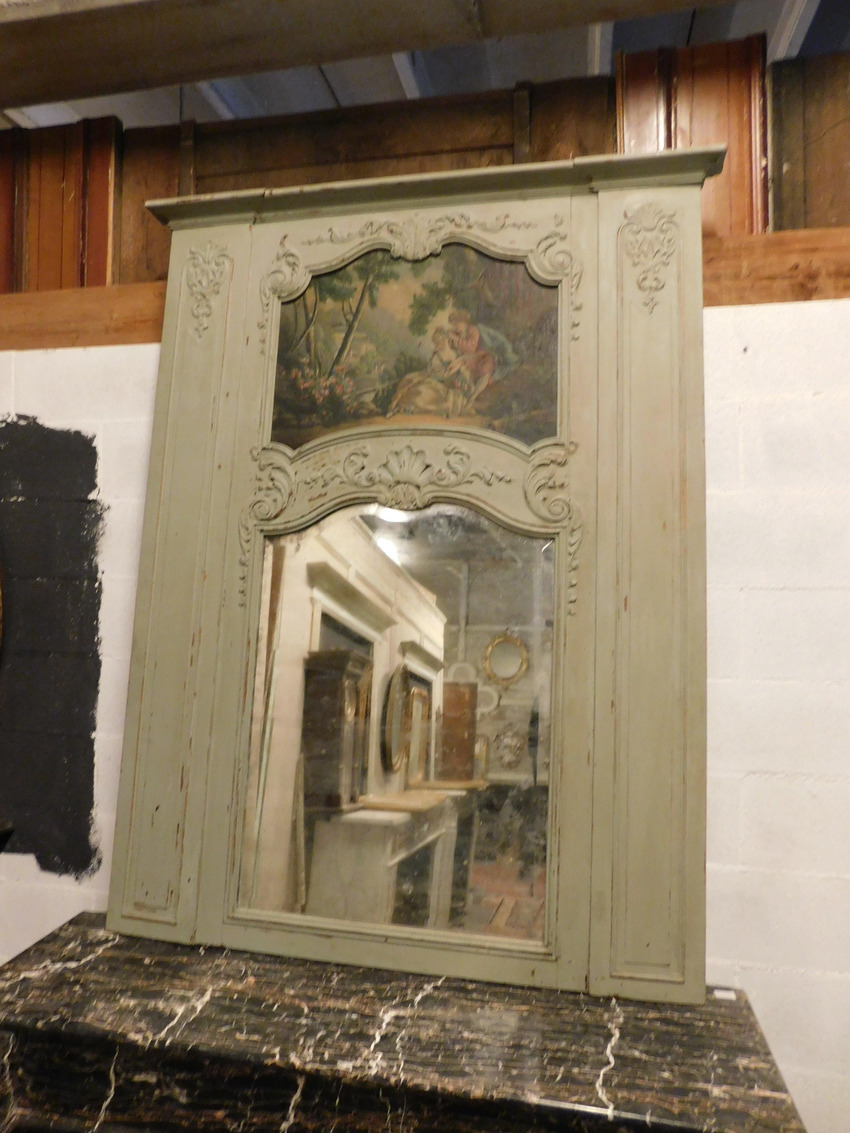 Ancient mirror above the fireplace, hand lacquered with painted in the upper part and frame with sculpted details, built in the 19th century in France, probably part of a boiserie, by now it could be used as a large entrance mirror, as a fireplace,