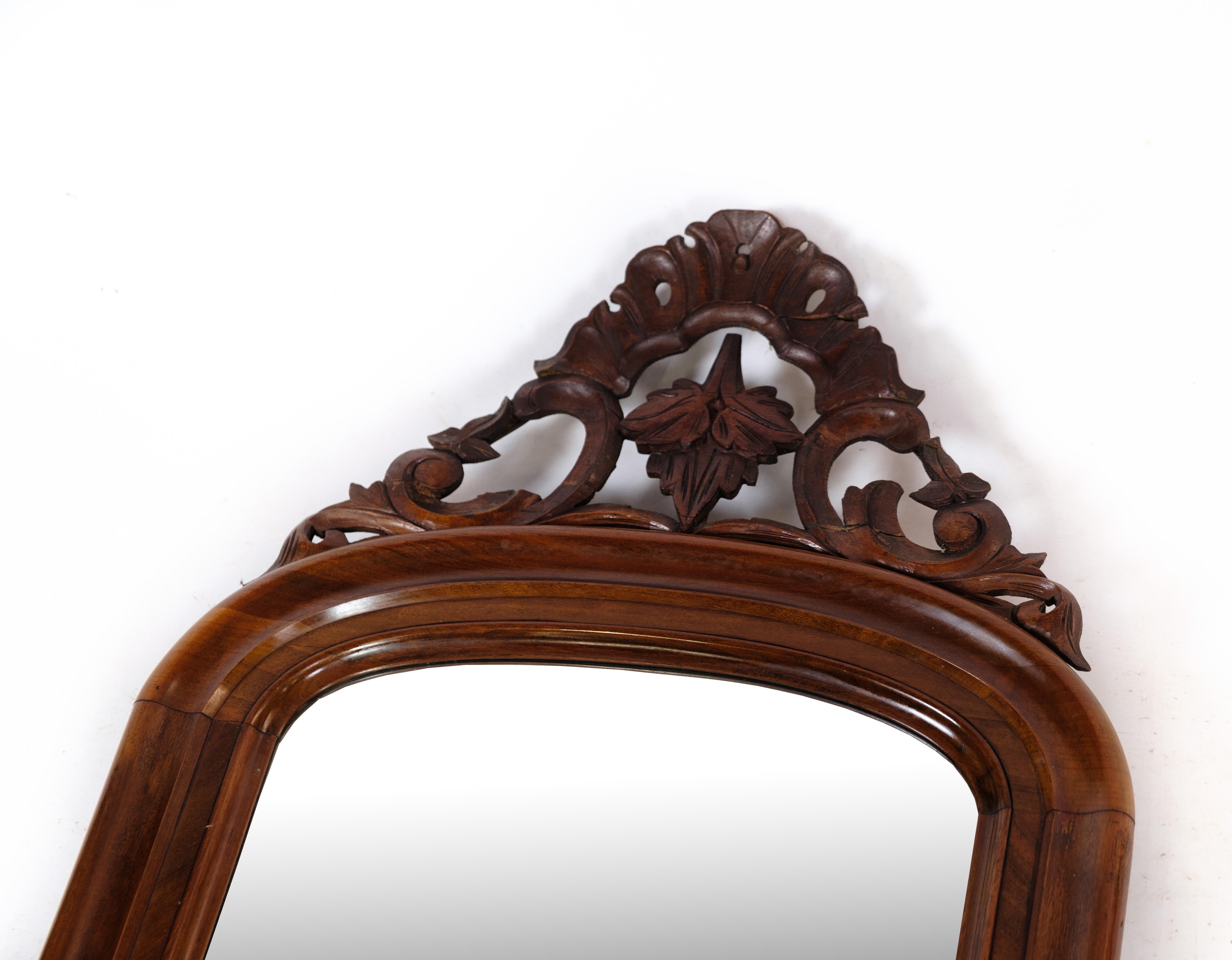 Antique mirror in mahogany wood, decorated with carvings from around the 1860s.
Dimensions in cm: H:127 W:53.