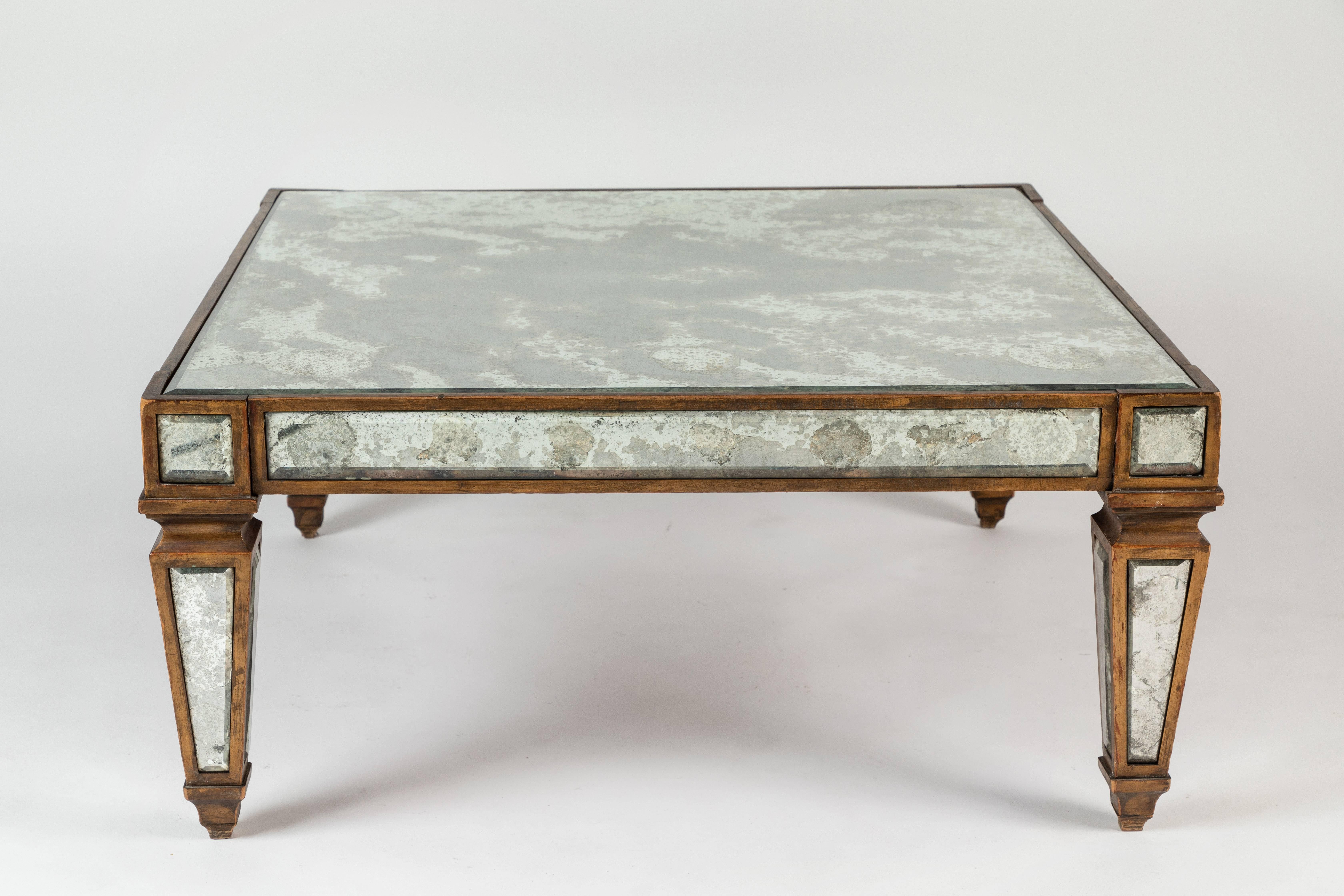 A hard to find “sick” antique mirrored cocktail table with a gold leafed wooden structure inlaid with antiqued mirror. A great square shape.
