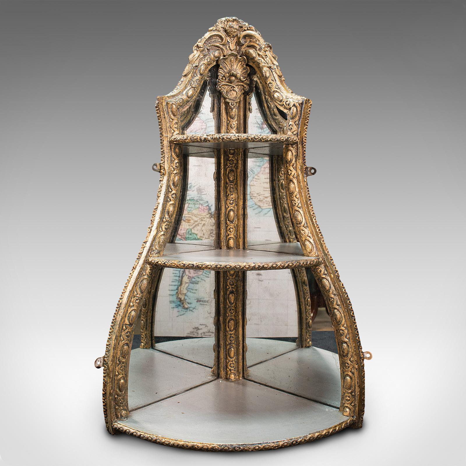 This is an antique mirrored corner shelf. An English, gilt gesso and glass decorative display or candle stand, dating to the Regency period, circa 1820.

Eye-catching form and finish to this appealing example of Regency craftsmanship
Displaying a