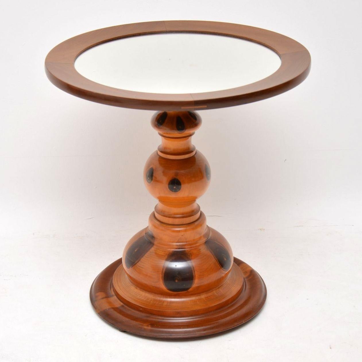 This antique occasional table is made from a very unusual wood, which I can’t quite figure out. I think it could olive wood, but whatever it is, it has some very distinct figuring in the wood.

This table has an inset mirror on the top and a