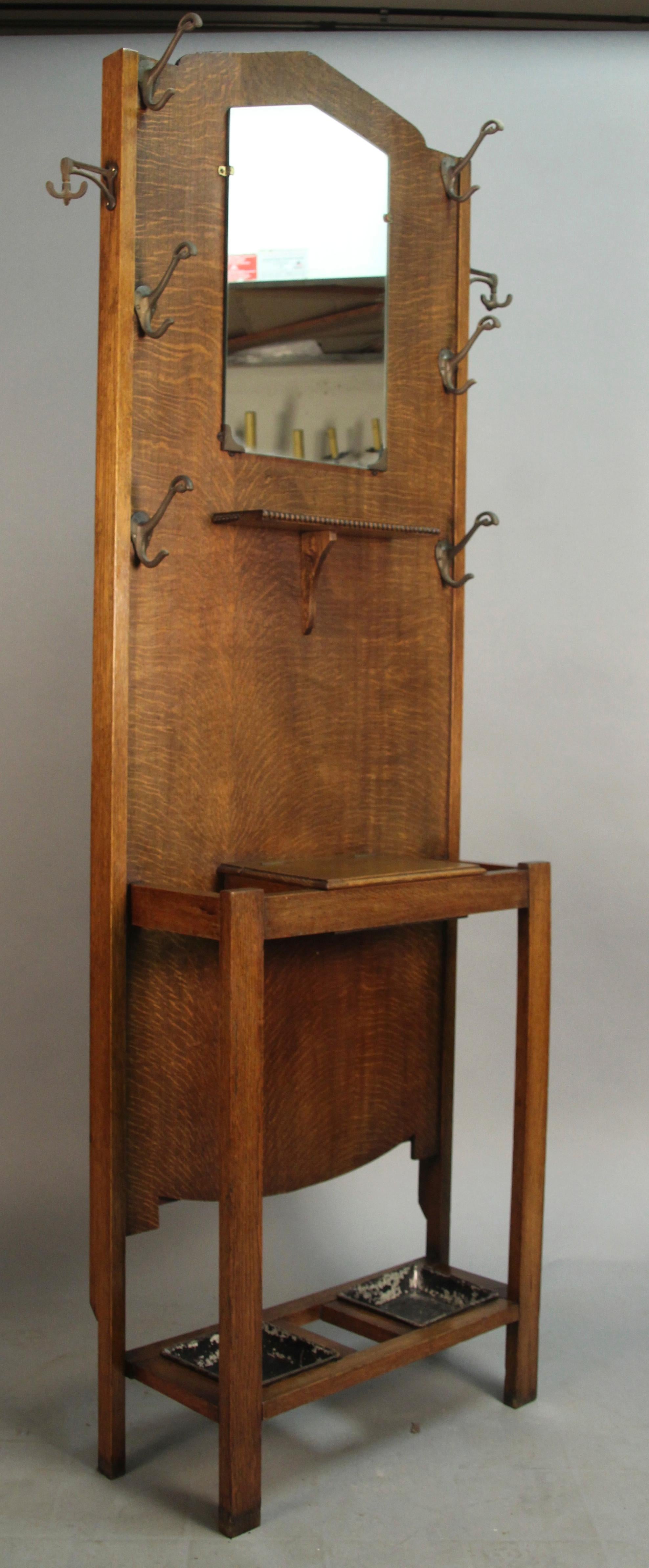 Hall tree with several hooks, umbrella stand, shelf with storage and mirror, circa 1910.