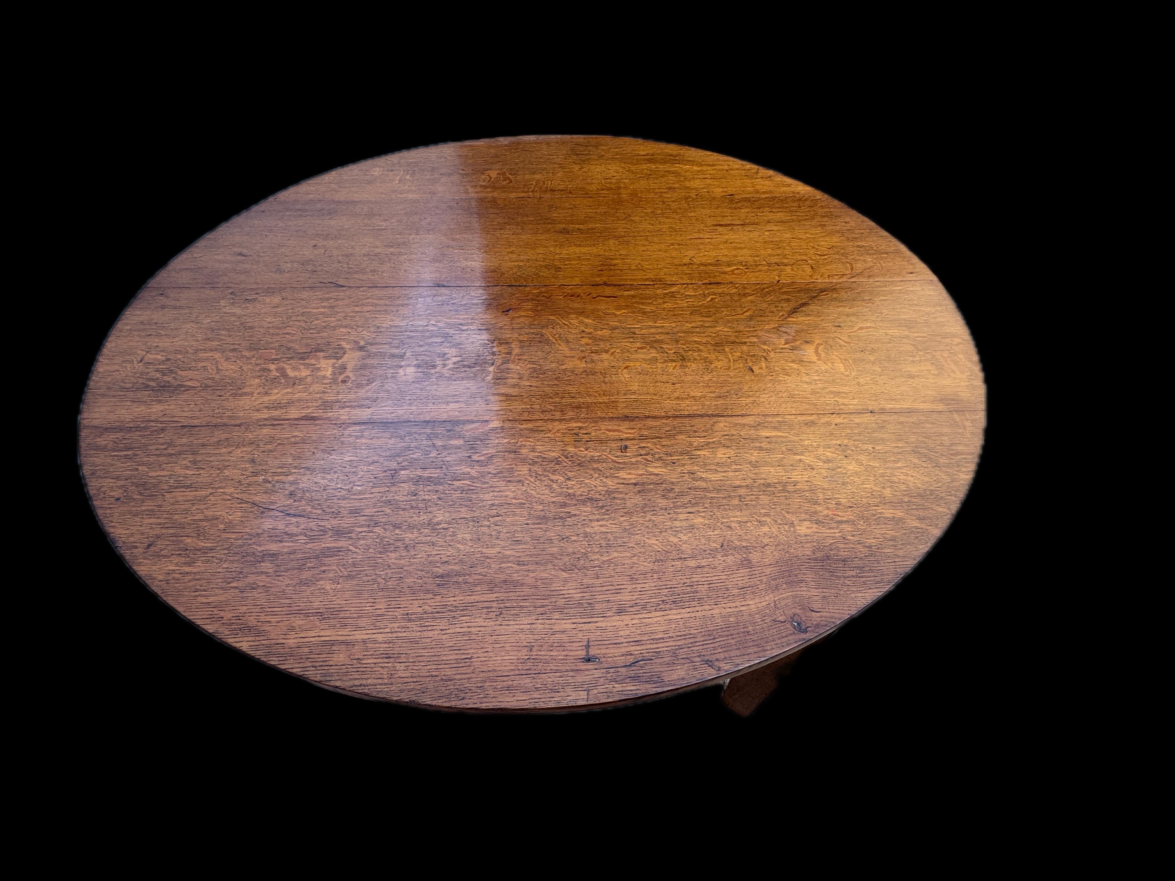 Antico tavolo da pranzo Mission Arts & Crafts rotondo in quercia segata a quarto di dollaro dell'inizio del XX secolo, composto da quercia massiccia segata a quarto di dollaro con gambe quadrate gradualmente affusolate collegate da barre trasversali
