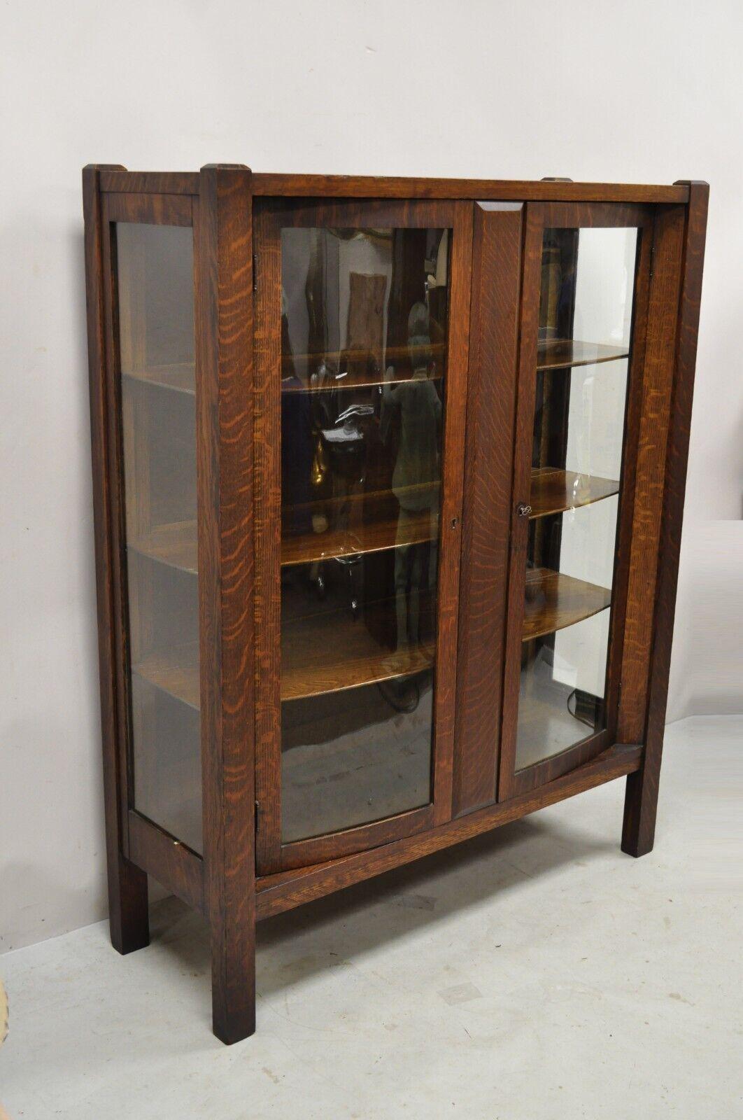 Antique mission oak arts & crafts stickley era 2 door China cabinet. Item features a beautiful wood grain, 2 curved swing doors, working lock and key, 3 wooden shelves, very nice antique item, quality American craftsmanship. Circa early 1900s.