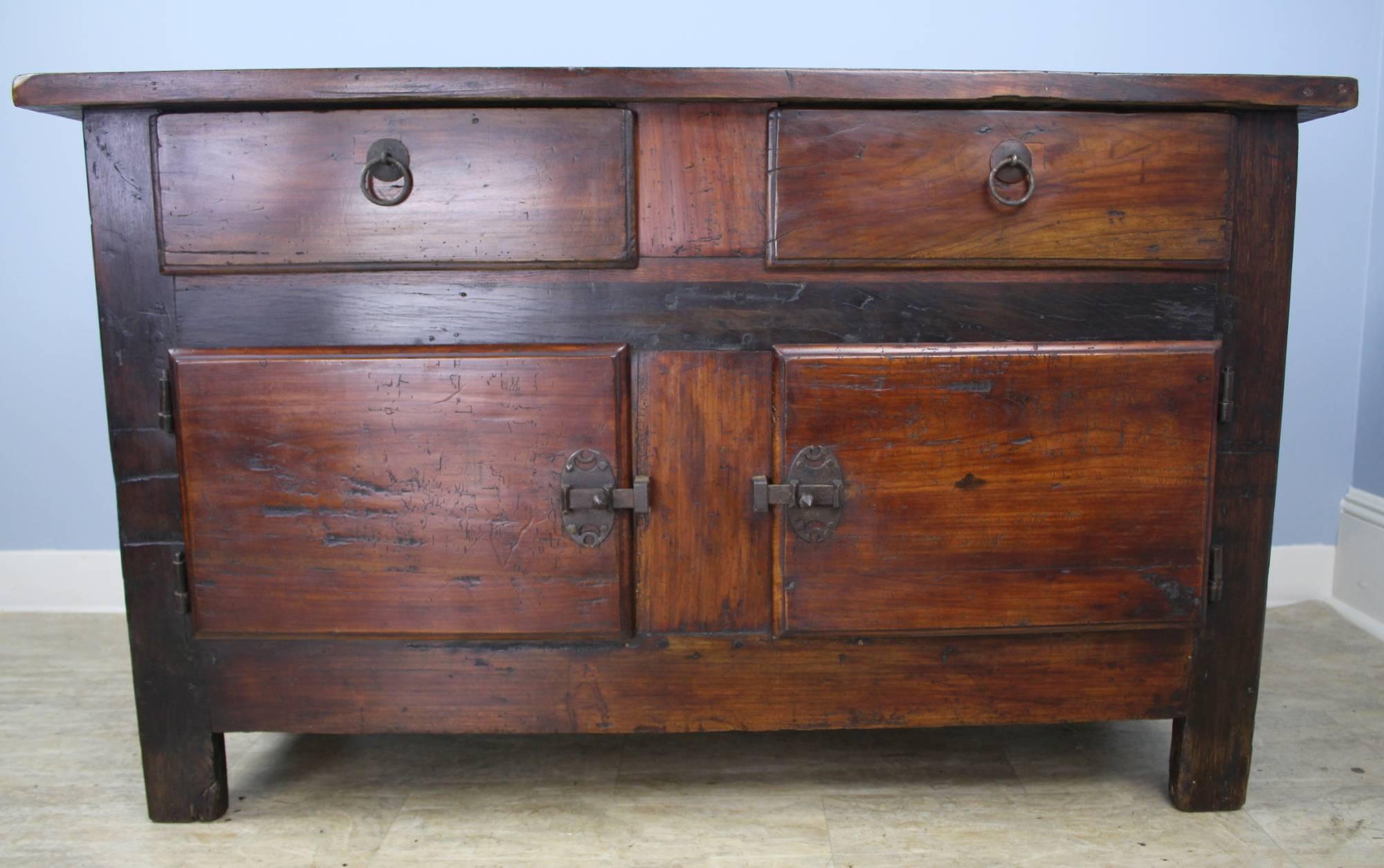 A handsome buffet or console fashioned of mixed fruitwoods. Large storage space under two roomy drawers. Rustic wrought iron hardware with classic ring pulls.