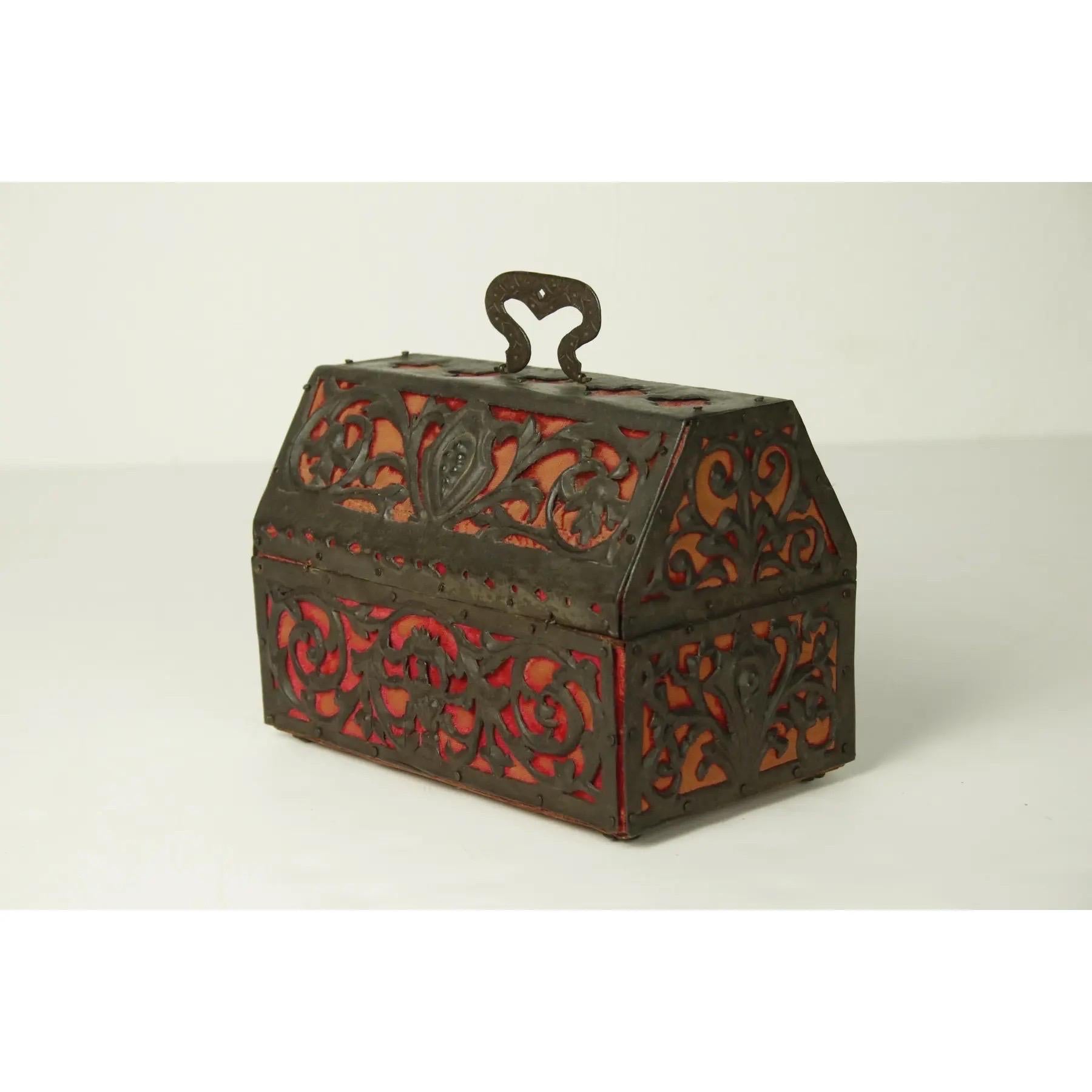 A Mizner Spanish / Mediterranean pierced copper & velvet box with red damask interior. The box is framed with elaborately scrolled vine-like acanthus over a red velvet fabric with diamond piercings at the shoulders. The lid opens with a swan necked