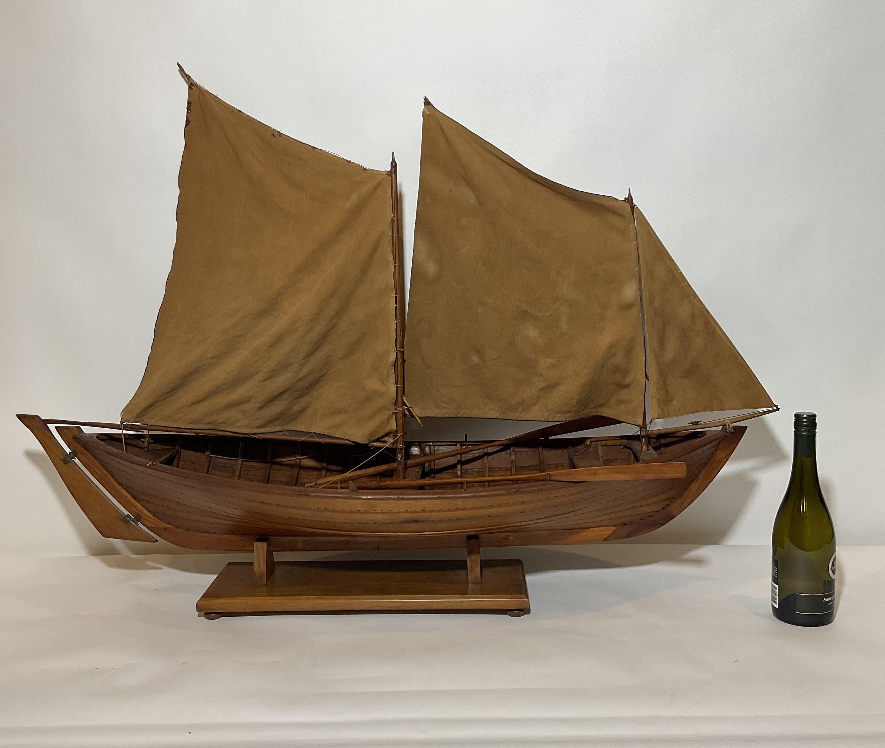 Plank of frame model of a two masted lateen rigged open hulled coastal transport craft planked and ribbed hull with benches. Two varnished oars are on board. Expertly built. Circa 1920.

Weight: 5 lbs.
Overall Dimensions: 32