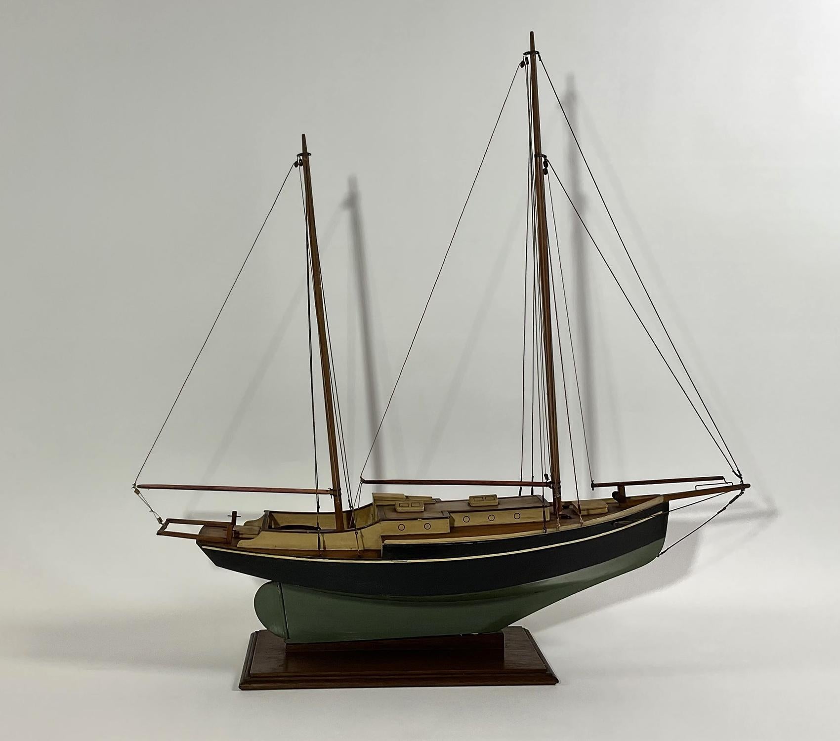 Early twentieth century model of a two masted ketch with crème painted trunk cabin and deckhouse. Well rigged. Green and black painted hull. Circa 1950.