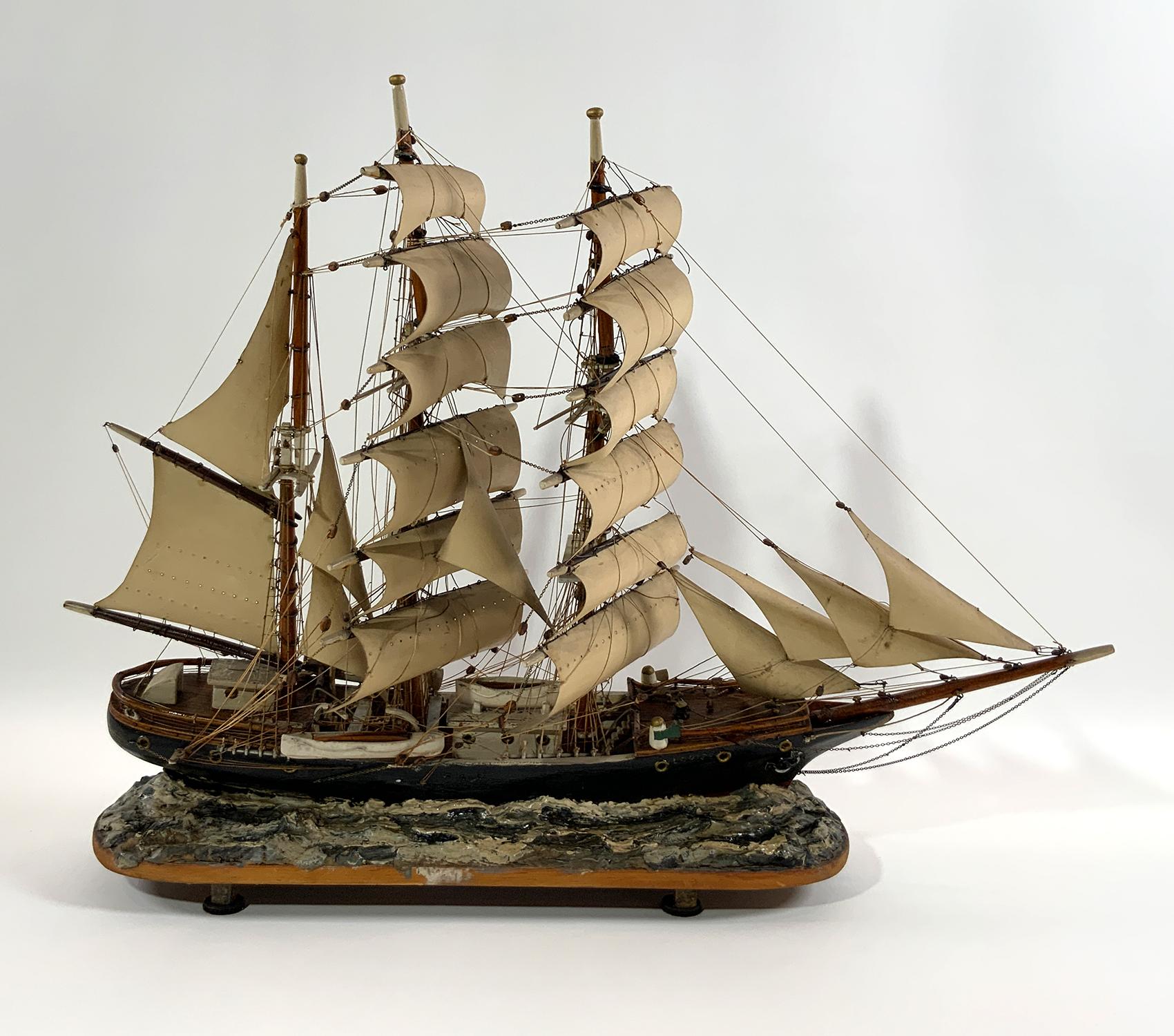 Charmante maquette de bateau antique représentant le Windjammer Louise naviguant à pleine voile sur des vagues d'argile. Superbe modèle de bateau ancien.
