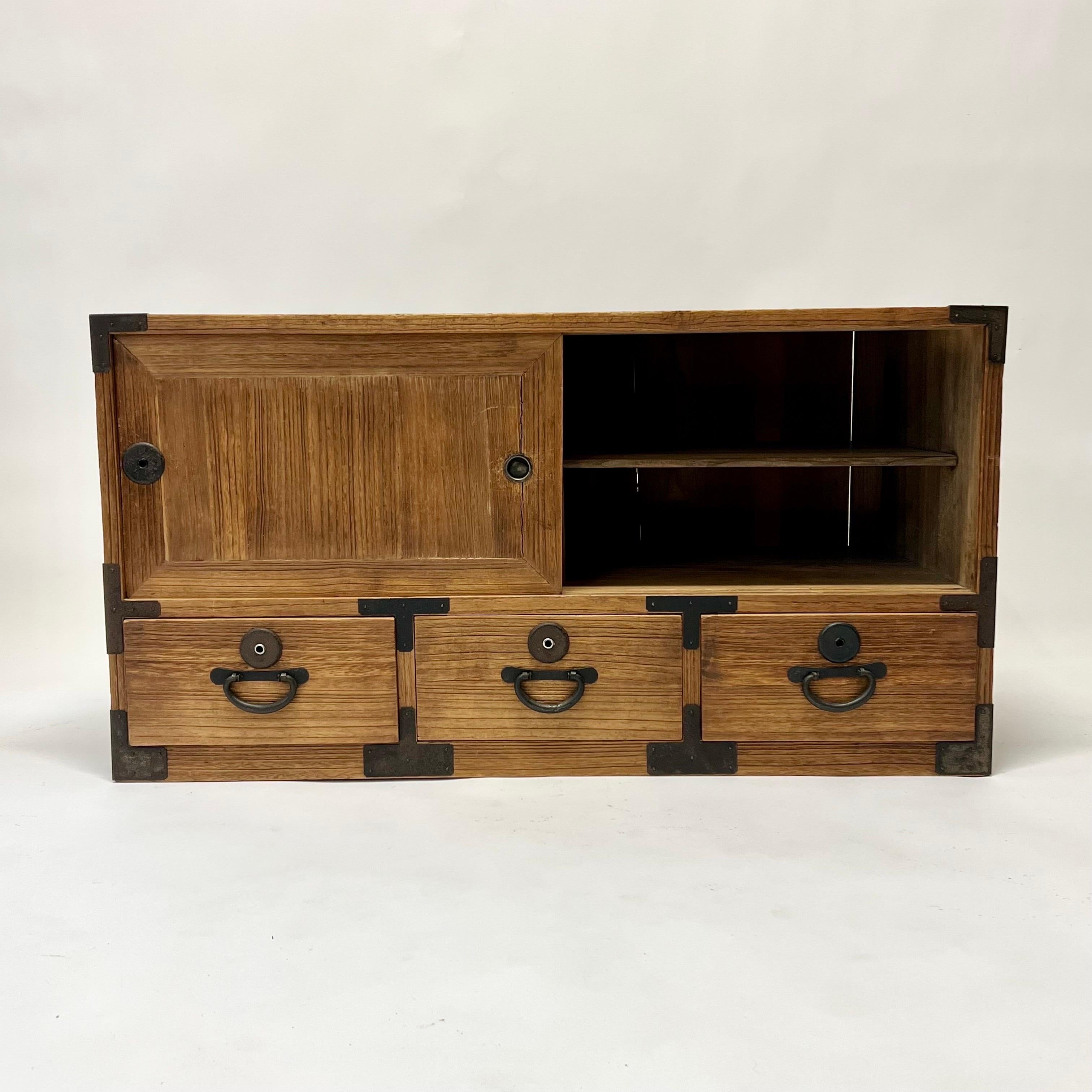 Gorgeous low antique Japanese Tansu from the early 1900s with wonderful detail and patina. Very functional piece with a shelf on the right side, and open on the left. Three drawers on the bottom. Iron handles that stay hidden when not in use. All