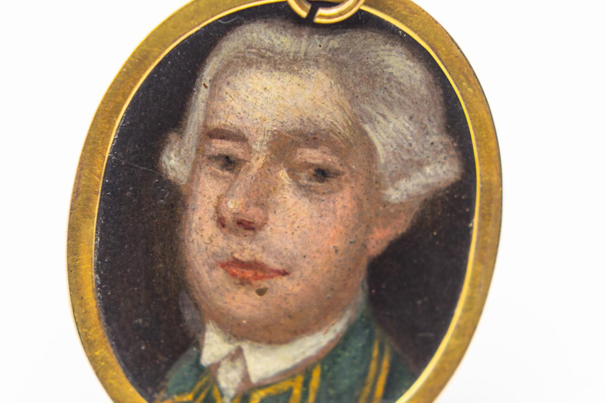 Antique modest school c 1790 English portrait painting pendant. A small miniature of a gentleman with a powdered wig tied with a black bow and daring to circa 1760. The enlarged pictures show a patch on his forehead which is not particularly