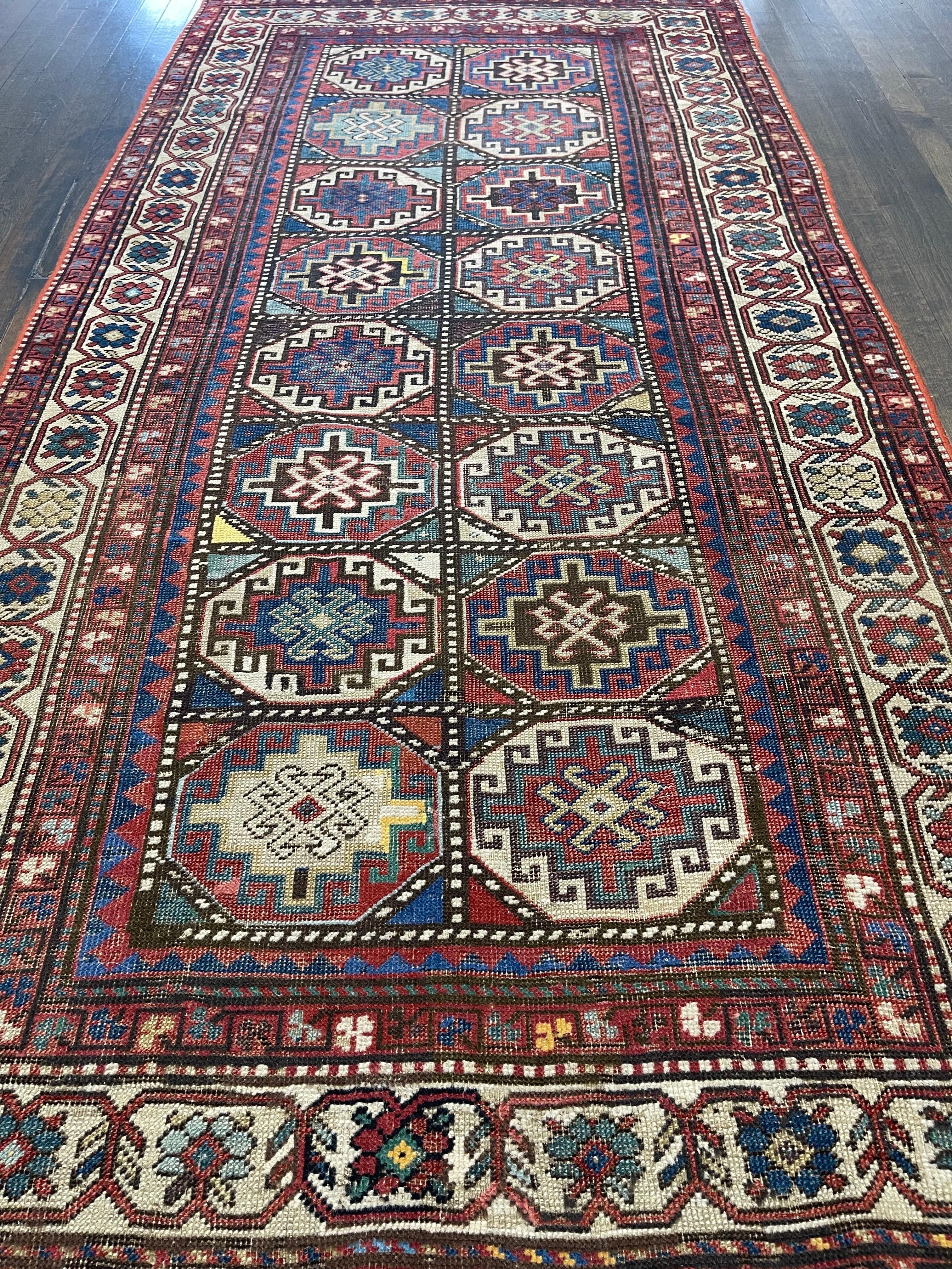 A handsome Kazak runner created in Moghan,south west of caucus featuring sixteen rows of Memlinc Gul lattice within the octagon in double vertical rows with a variety of bright colors. This striking example of Kazak, is either the work of a novice
