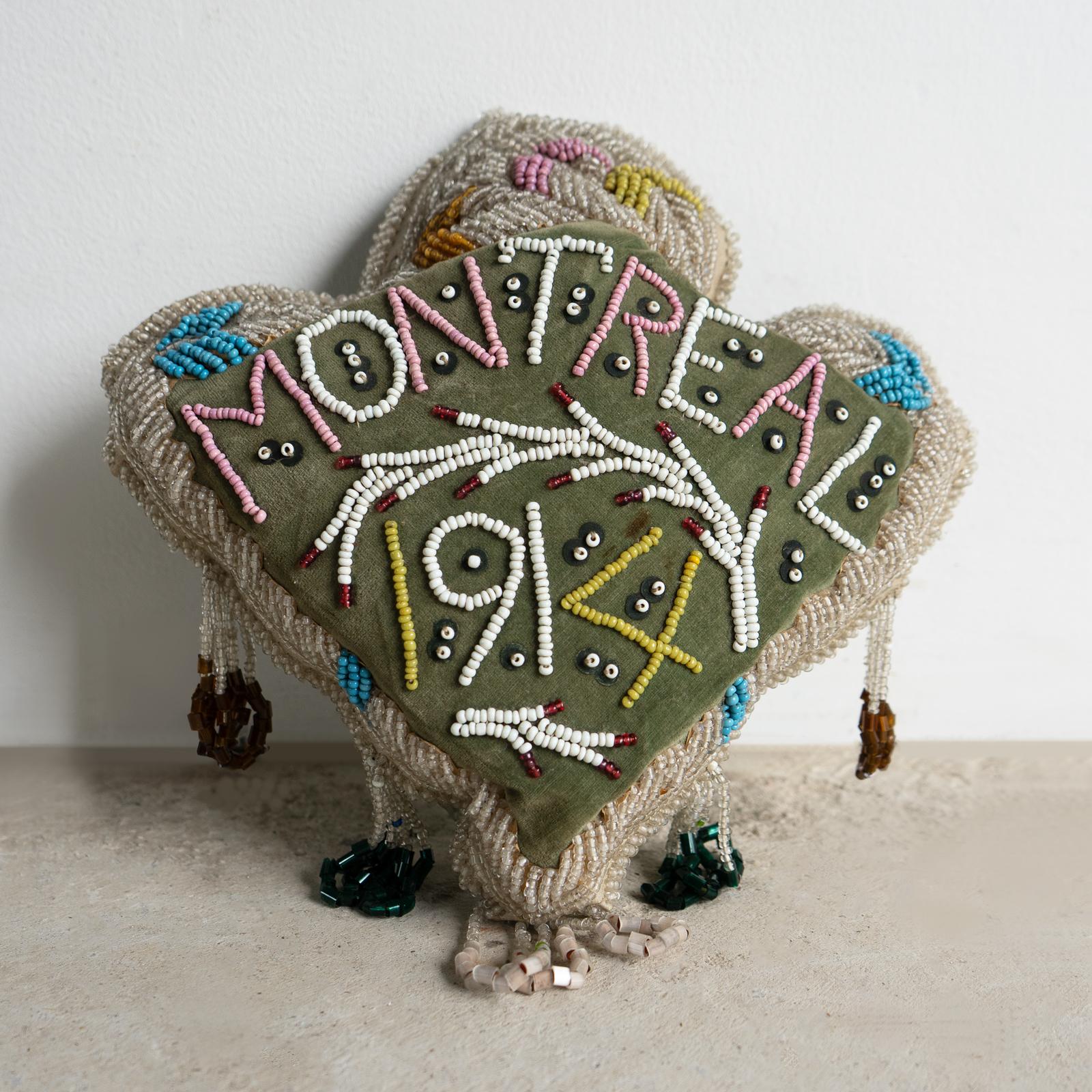 ANTIQUE NATIVE AMERICAN/CANADIAN FIRST NATION CUSHION/PILLOW 

A pine sawdust-stuffed cushion with intricate and highly decorative glass beadwork on a green velvet ground, inscribed ‘Montreal’ and dated ‘1914’.

This shape is sometimes known as a