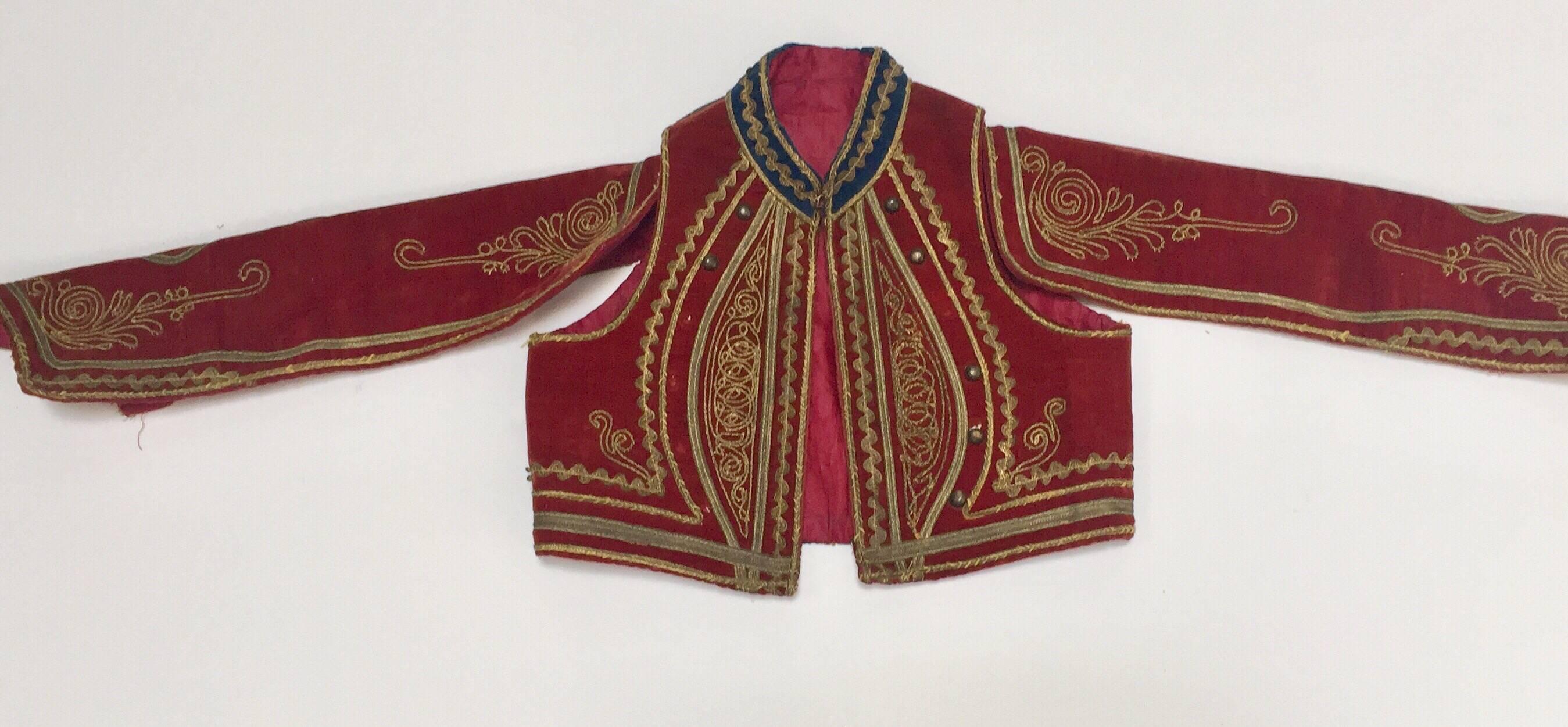 Veste Efe Zeybek du début du 20e siècle du Moyen-Orient.  
Costume Efe Zeybek pour enfant Gilet ethnique turc authentique.
Velours rouge marron foncé avec des feuillages dorés et une bordure dorée.  Manches ouvertes, doublure en coton rouge.
Veste